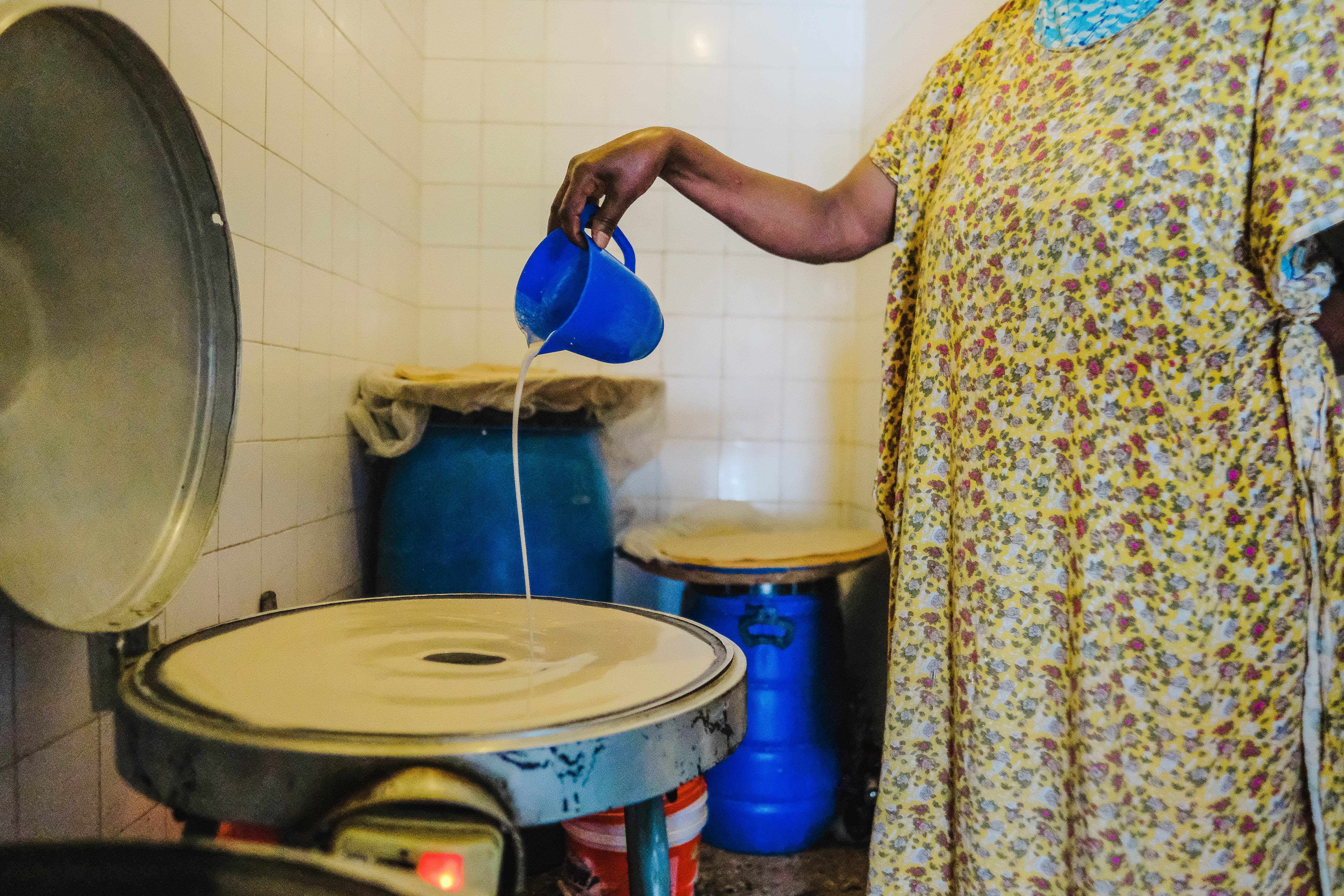 A cook pours the fermented teff batter onto a griddle to make injera
