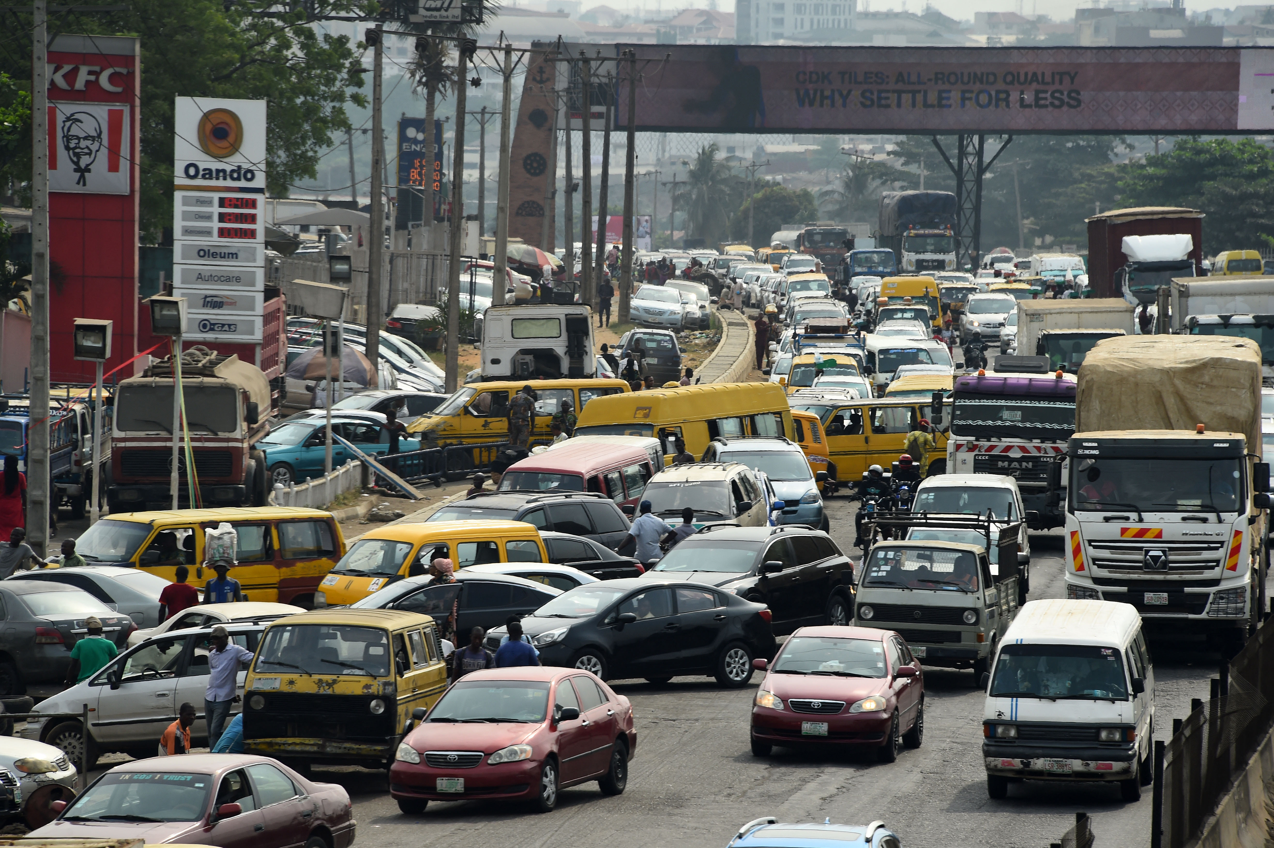 Drivers wait in line to buy fuel at and next to a filling station, causing traffic gridlock on Lagos' Ibadan expressway