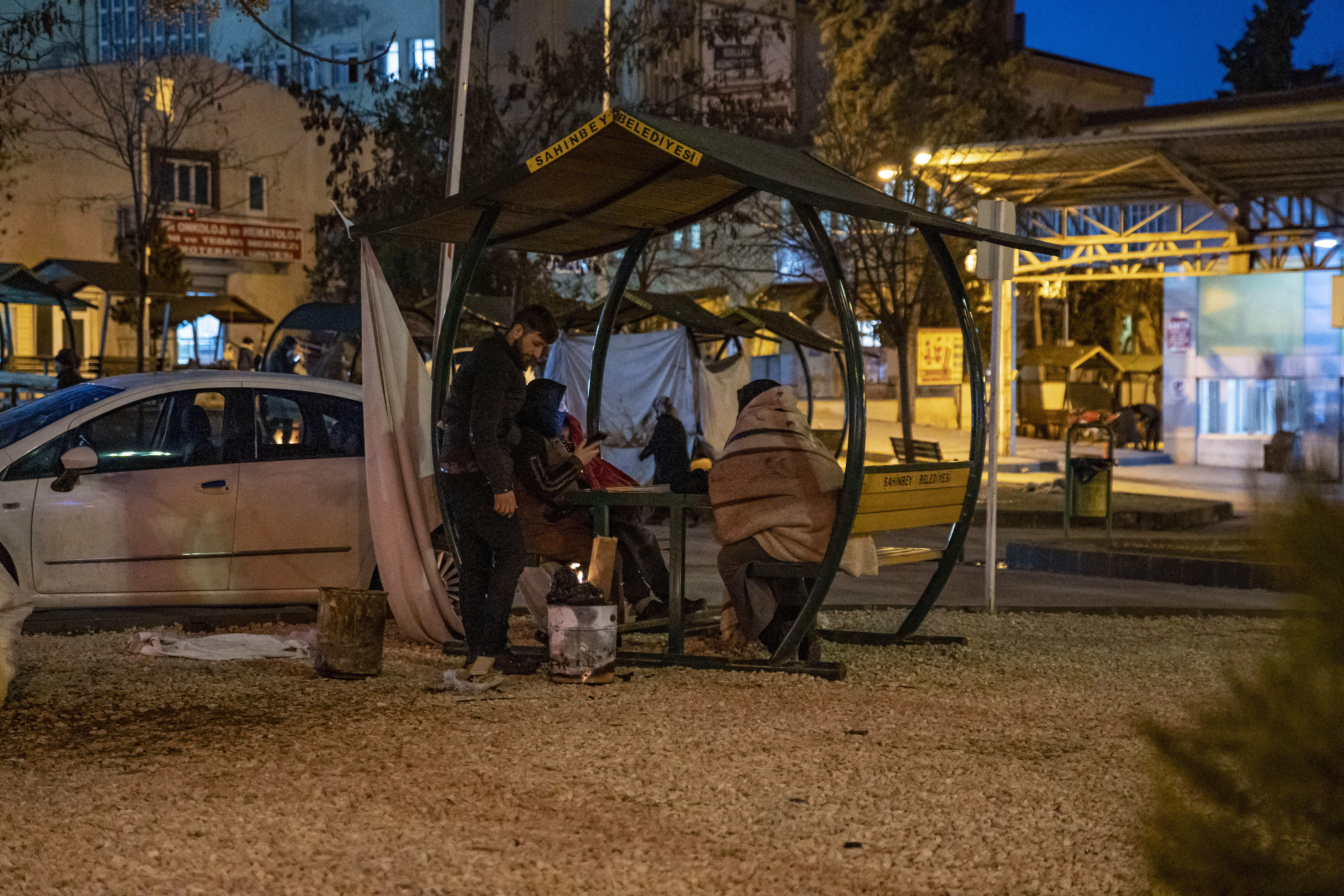 A family uses a public park bench to sleep for the night in front of Ersin Arslan Hospital in Gaziantep
