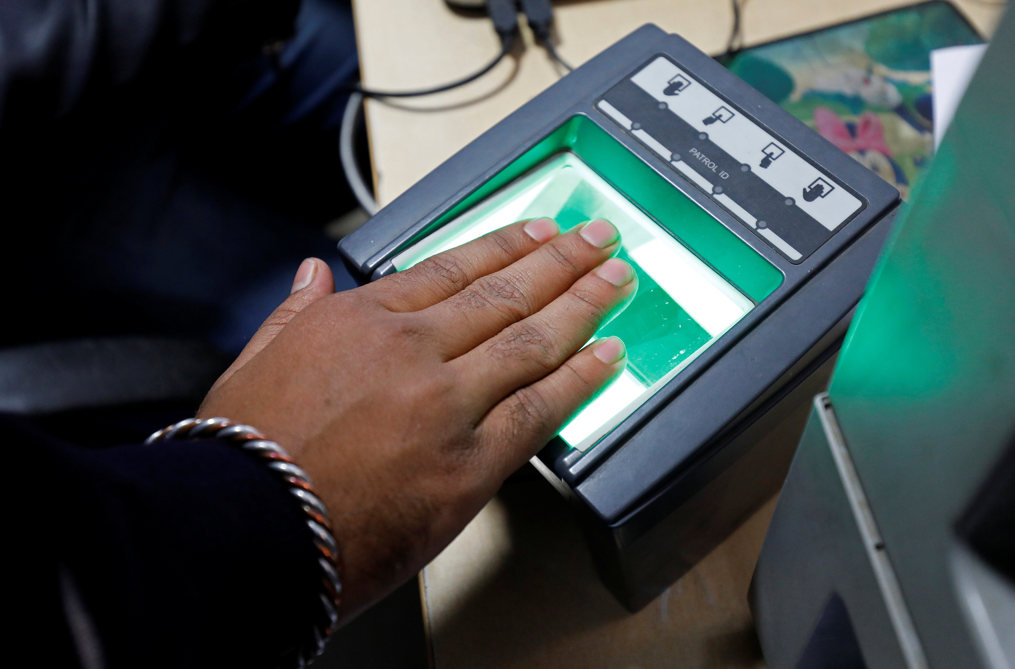 A woman goes through the process of finger scanning for the Unique Identification database system
