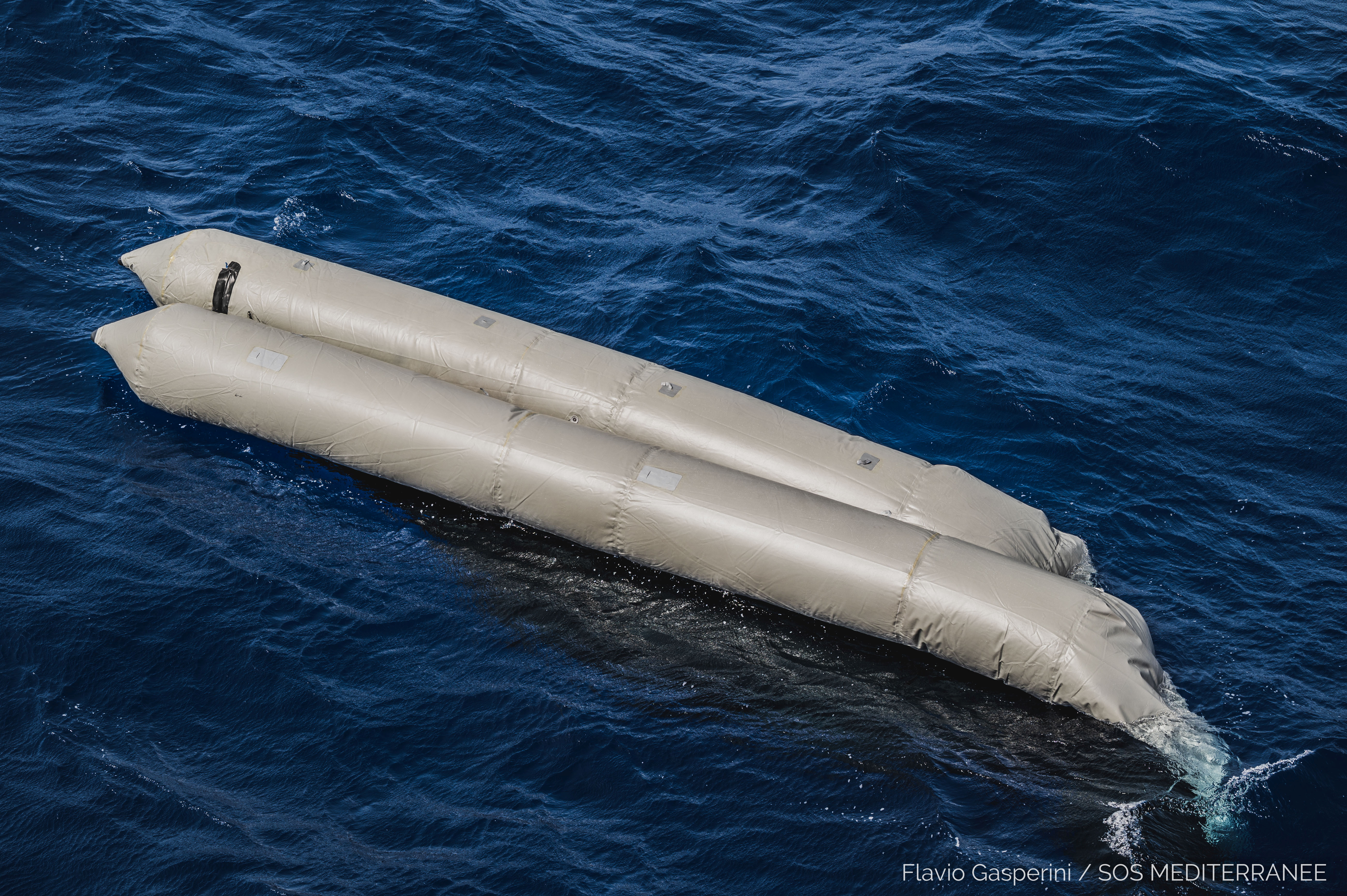 A rubber boat is seen after having capsized