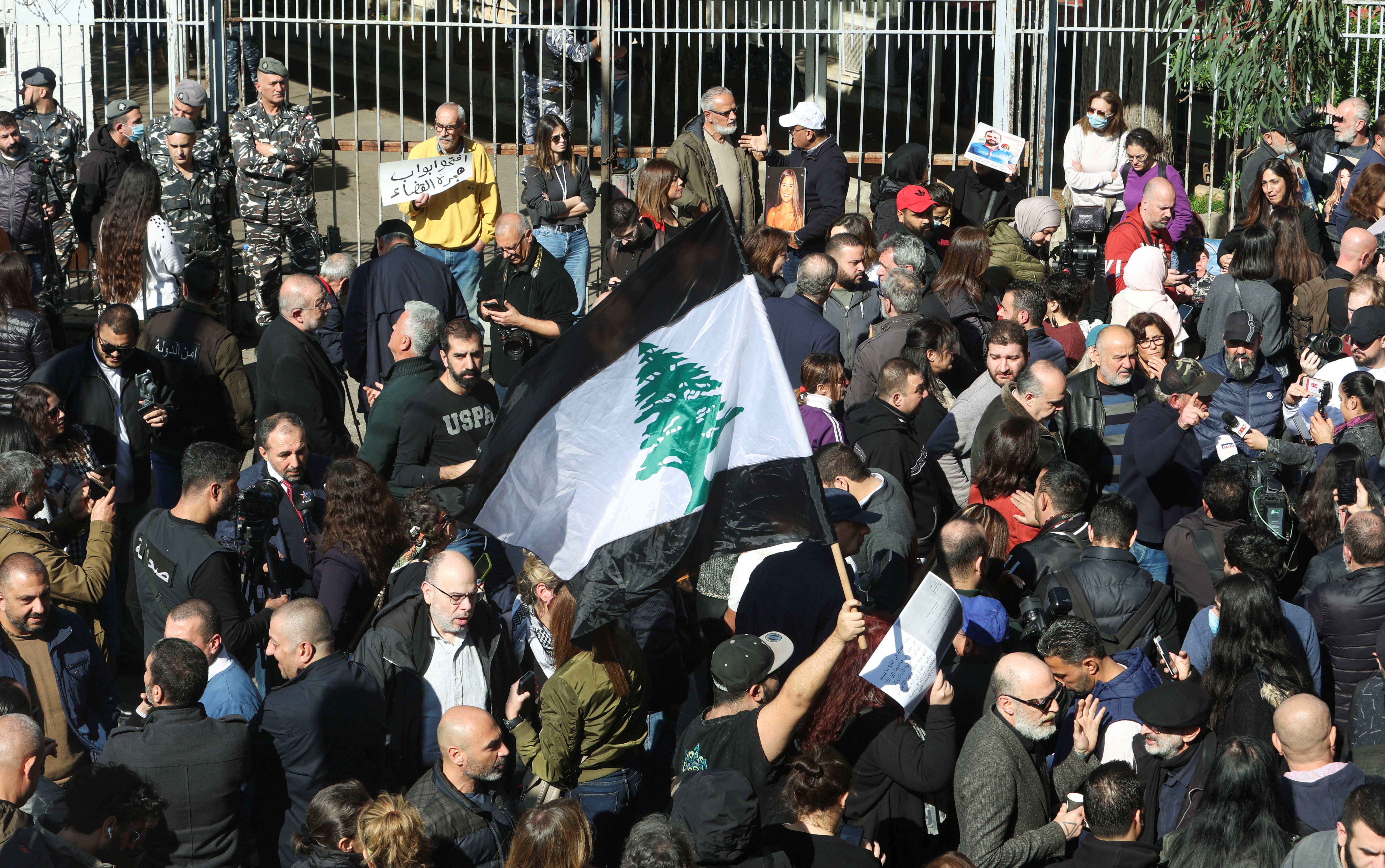 A demonstrator holds a black and white Lebanese flag during a protest for Families of the victims of the 2020 Beirut port explosion against Lebanon's top public prosecutor who charged the judge investigating the Beirut port blast and ordered the release of those detained in connection with the explosion in front of the Justice Palace in Beirut, Lebanon January 26, 2023.