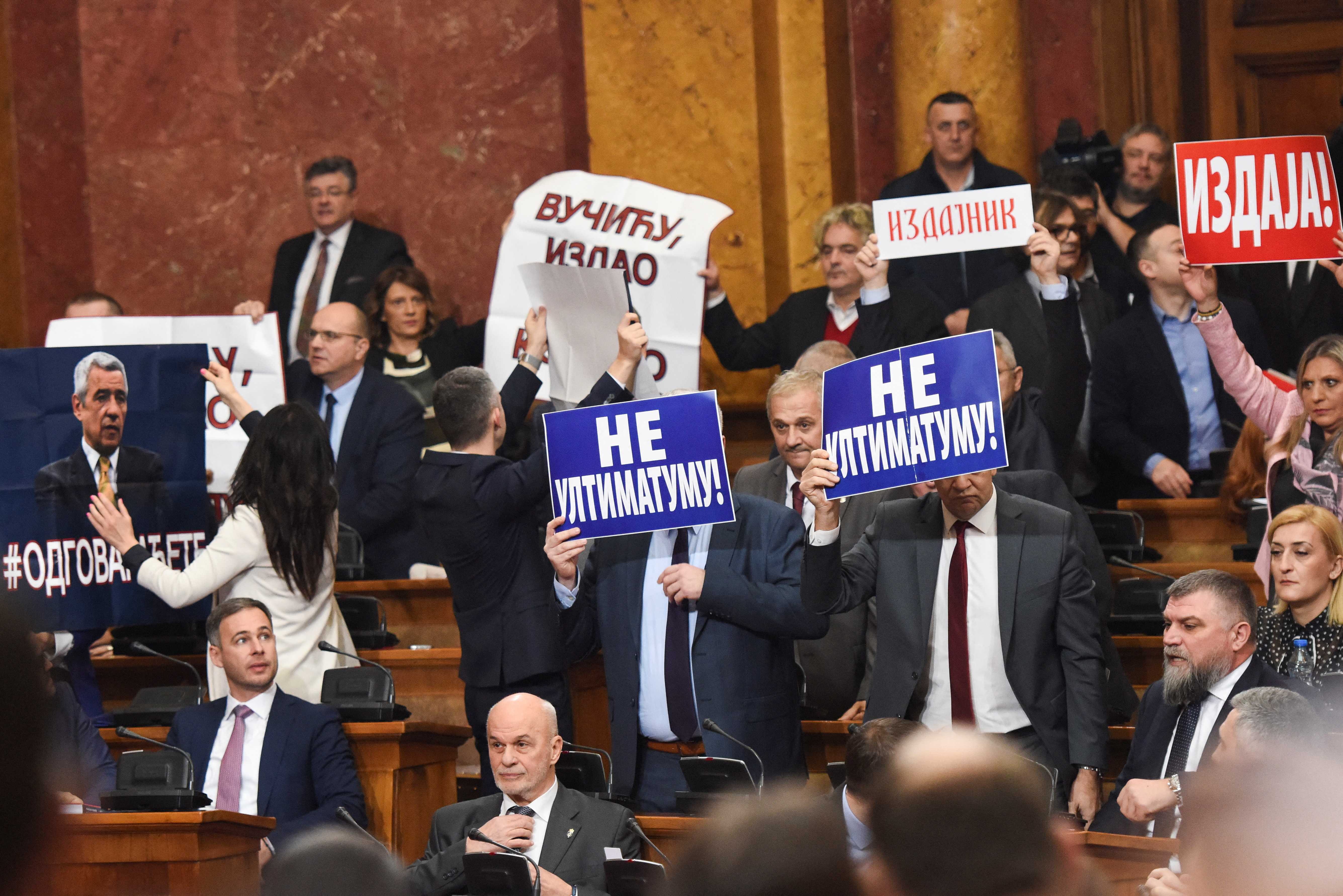 Lawmakers hold pictures of assassinated Kosovo Serb politician Oliver Ivanovic and banners that read: "Not to the ultimatum!" and "Vucic, betrayed Kosovo", during a special session of Serbia's parliament about the negotiating process with Kosovo in Belgrade, Serbia, February 2, 2023. REUTERS/Zorana Jevtic.