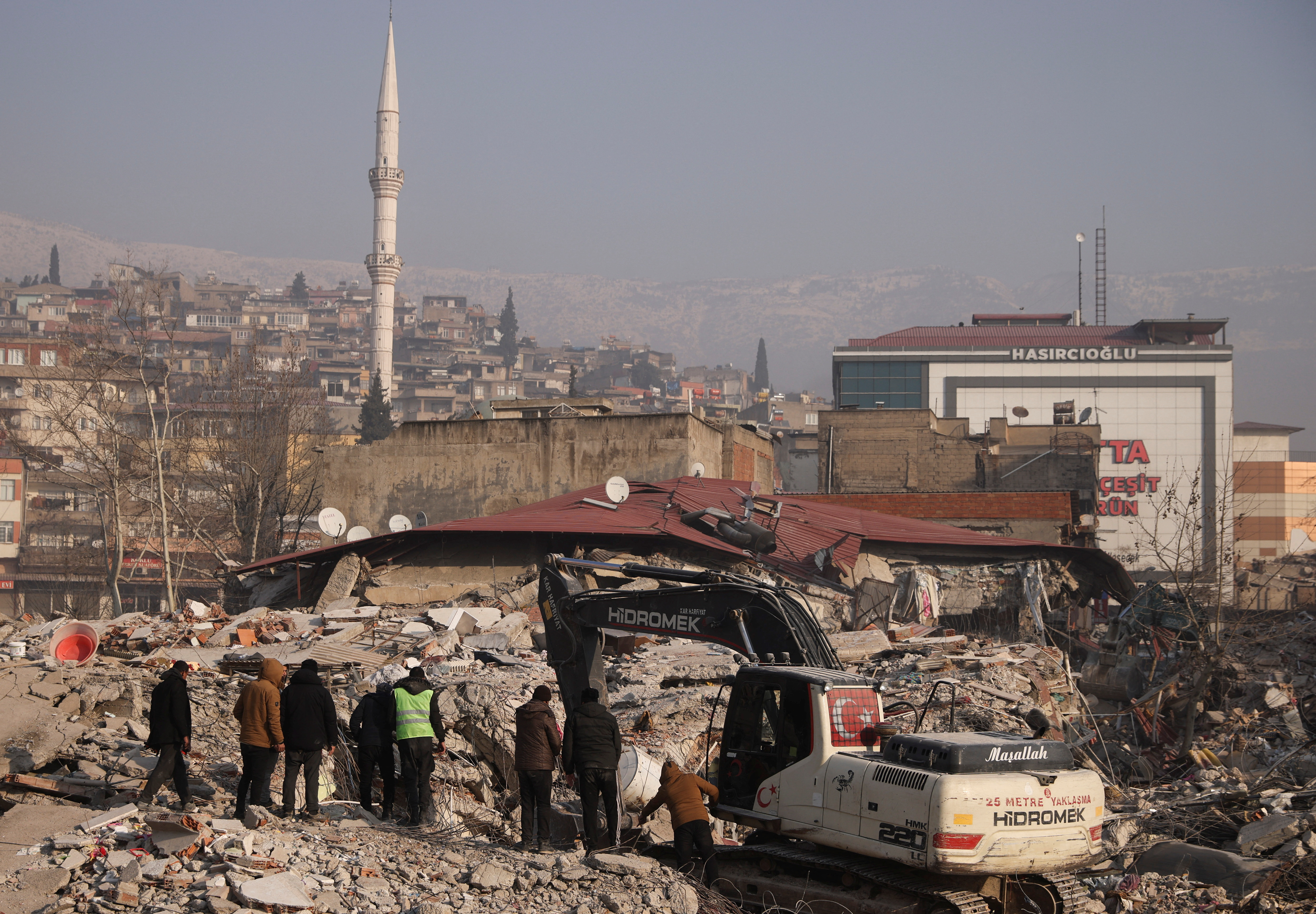 People stand amid rubble and damages, in the aftermath of a deadly earthquake in Kahramanmaras, Turkey February 12, 2023.