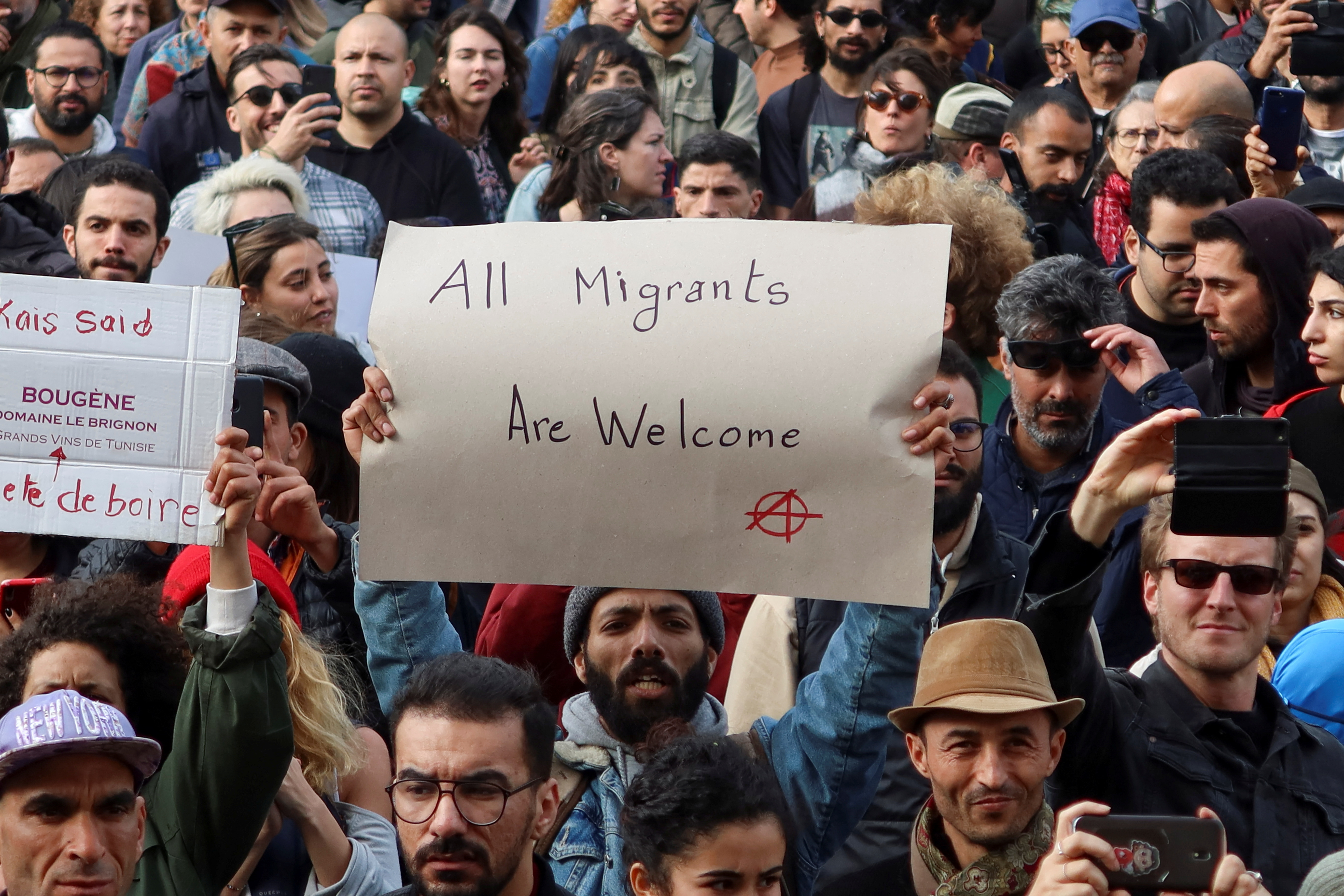 Members of rights groups carry banners during a protest, after Tunisian President Kais Saied ordered security forces to stop all illegal migration and expel all undocumented migrants, in Tunis, Tunisia February 25, 202