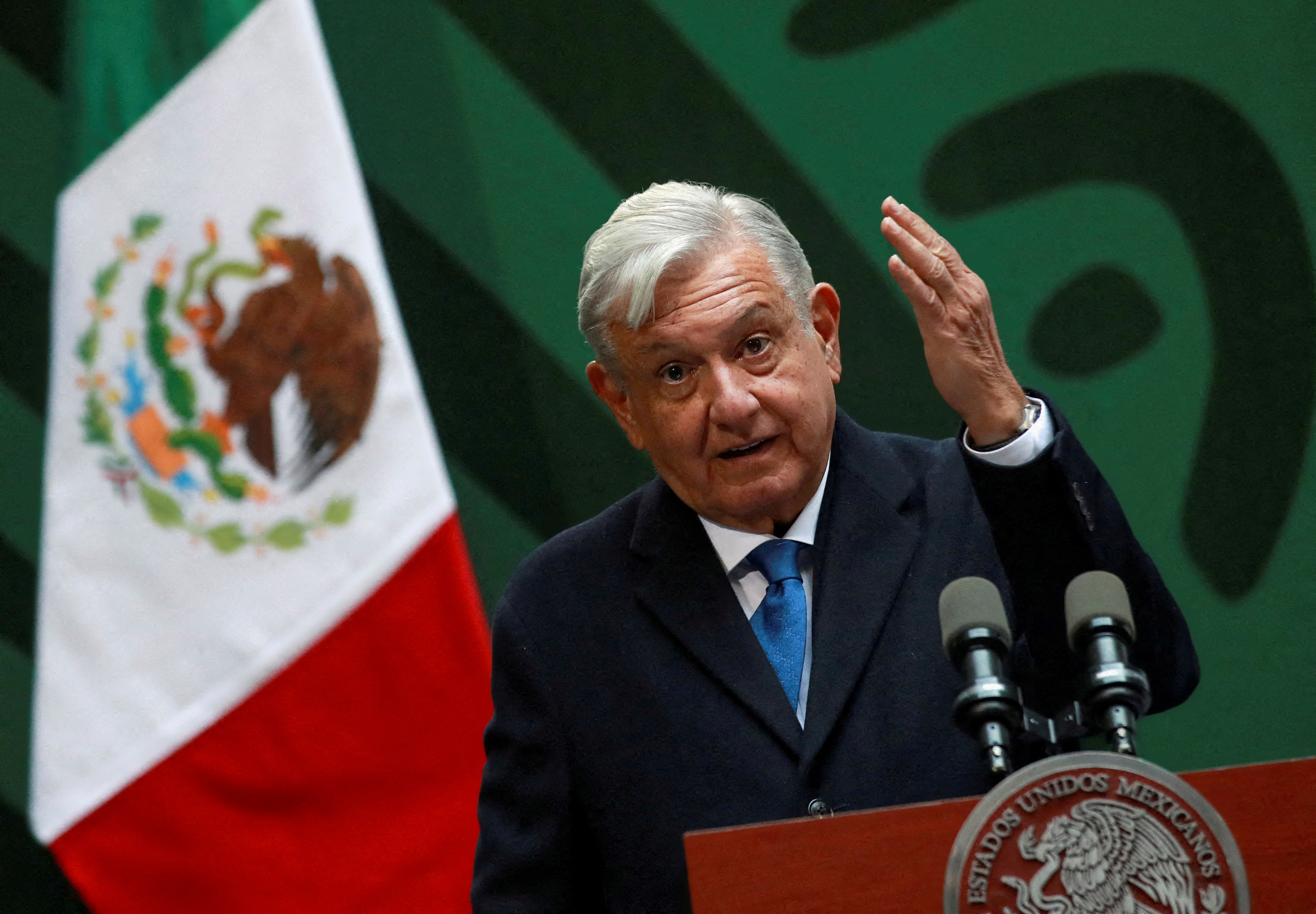 Andres Manuel Lopez Obrador speaks from a lectern at a press conference in Mexico City. A flag of Mexico is behind him.