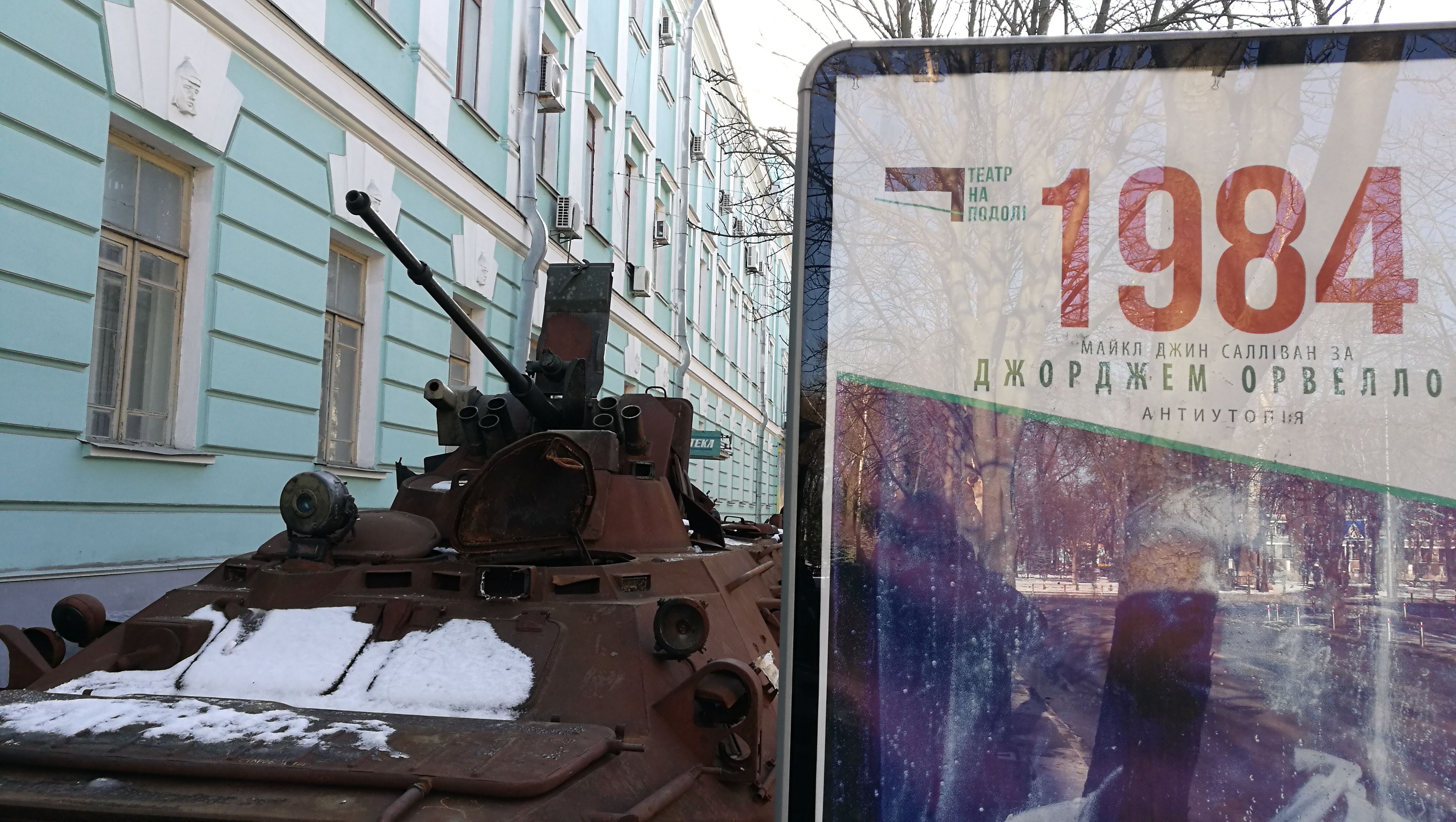 A-billboard-advertising-a-theater-performance-based-on-George-Orwells-1984-novel-next-to-a-damaged-Russian-tank-in-central-Kyiv.jpg