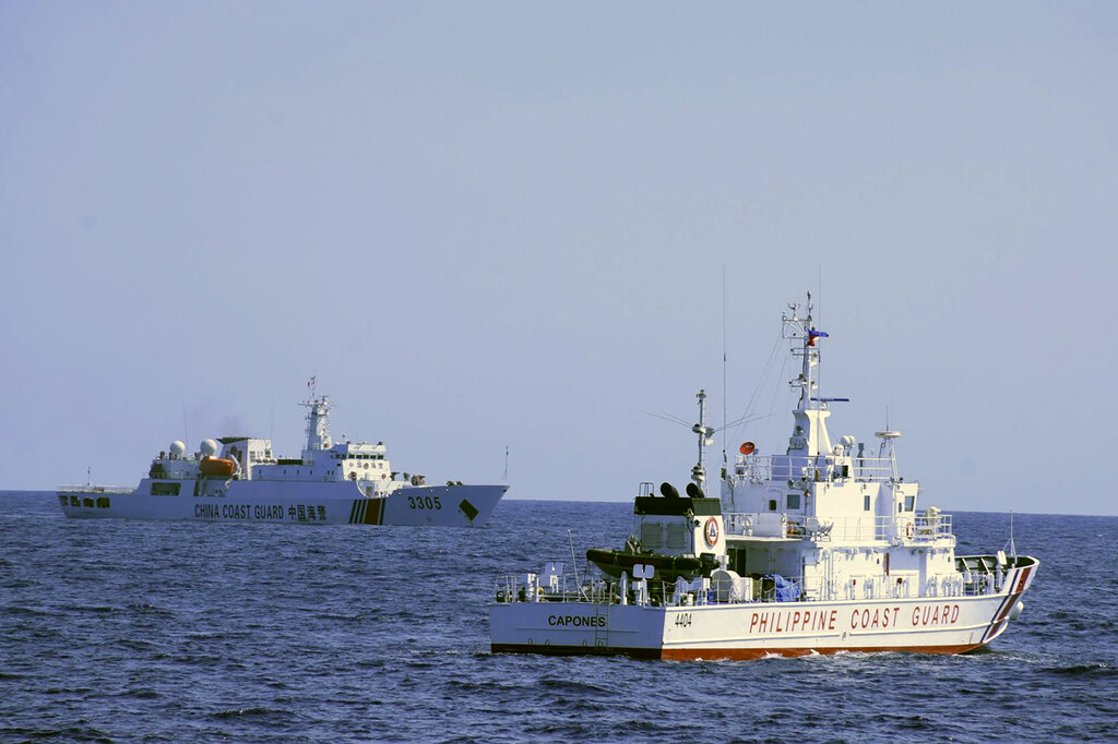 In this photo provided by the Philippine Coast Guard, a Chinese Coast Guard ship sails near a Philippine Coast Guard vessel during its patrol at Bajo de Masinloc, 124 nautical miles west of Zambales province, northwestern Philippines on March 2, 2022. The Philippines has sought an explanation from China after a Filipino military commander reported that the Chinese coast guard forcibly seized Chinese rocket debris in the possession of Filipino navy personnel in the disputed South China Sea, officials said Thursday, Nov. 24, 2022. (Philippine Coast Guard via AP)