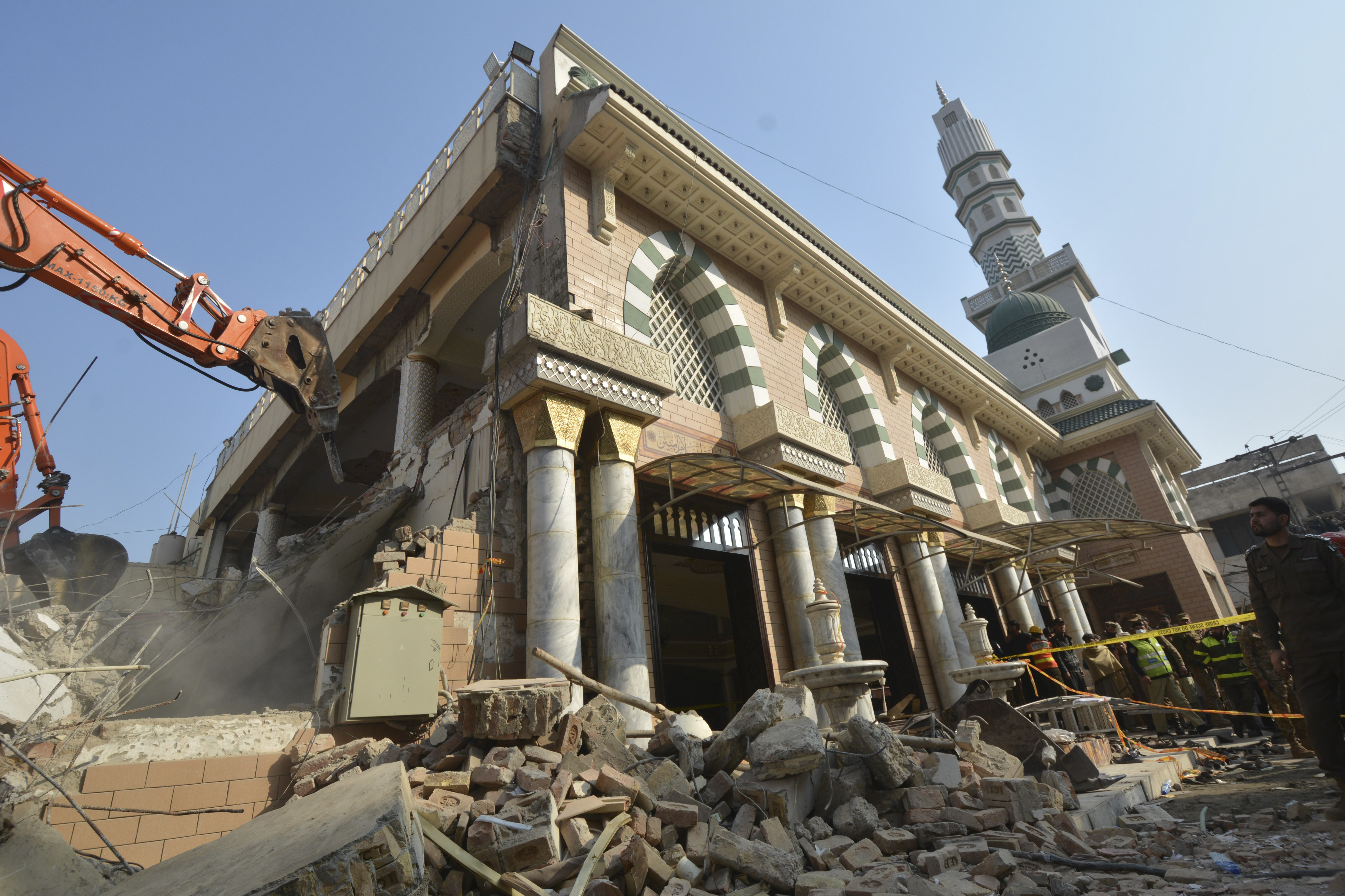 Authorities use heavy machinery to clear the rubble and search for bodies at the site of Monday's suicide bombing in Peshawar.