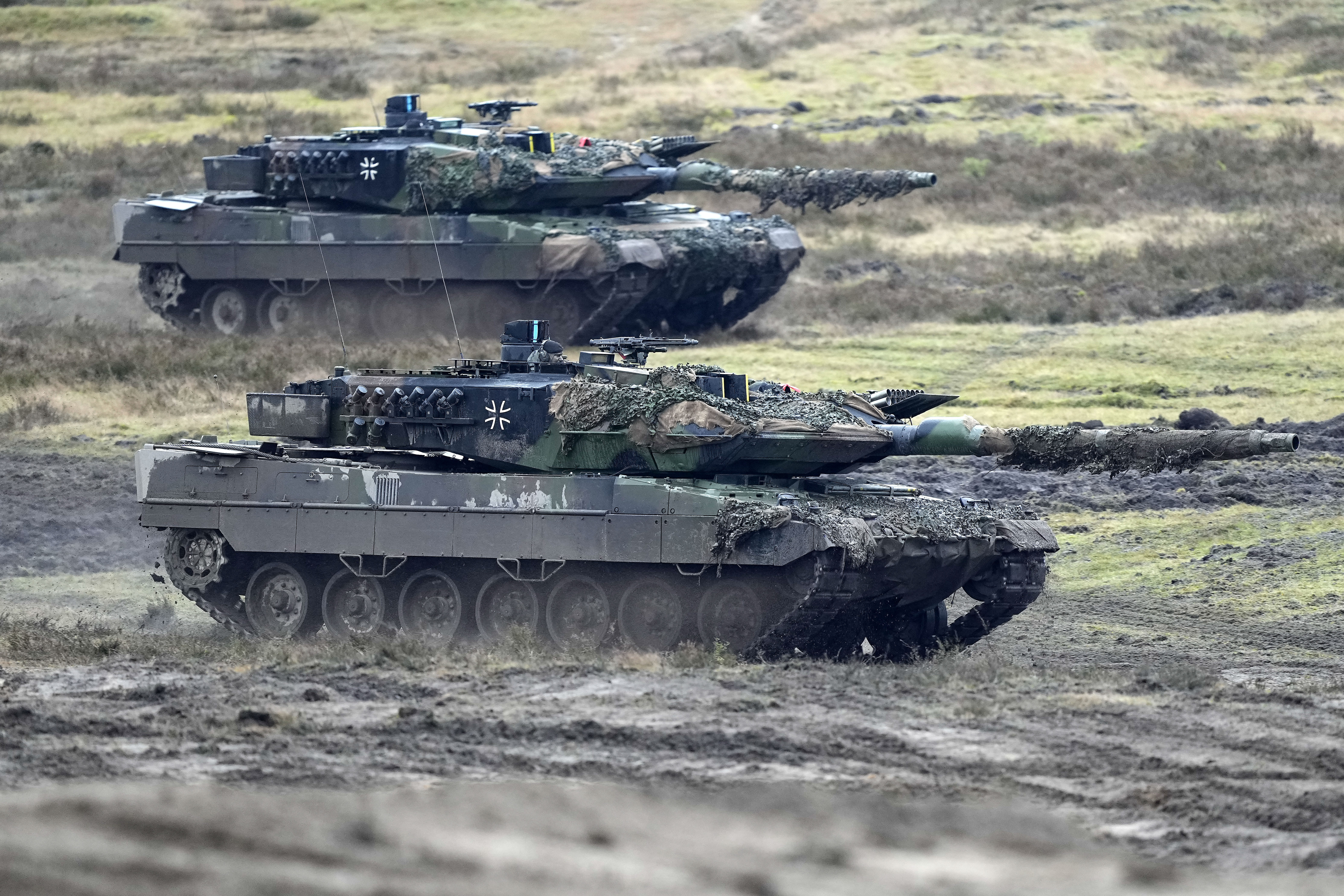 Two Leopard 2 tanks are seen in action during a visit of German Defense Minister Boris Pistorius at the Bundeswehr tank battalion 203 at the Field Marshal Rommel Barracks in Augustdorf, Germany, Wednesday, Feb. 1, 2023. After the government's decision to deliver fourteen Leopard 2 tanks to Ukraine, the capabilities of the Leopard 2A6 main battle tank are shown at a presentation in Augustdorf. (AP Photo/Martin Meissner)