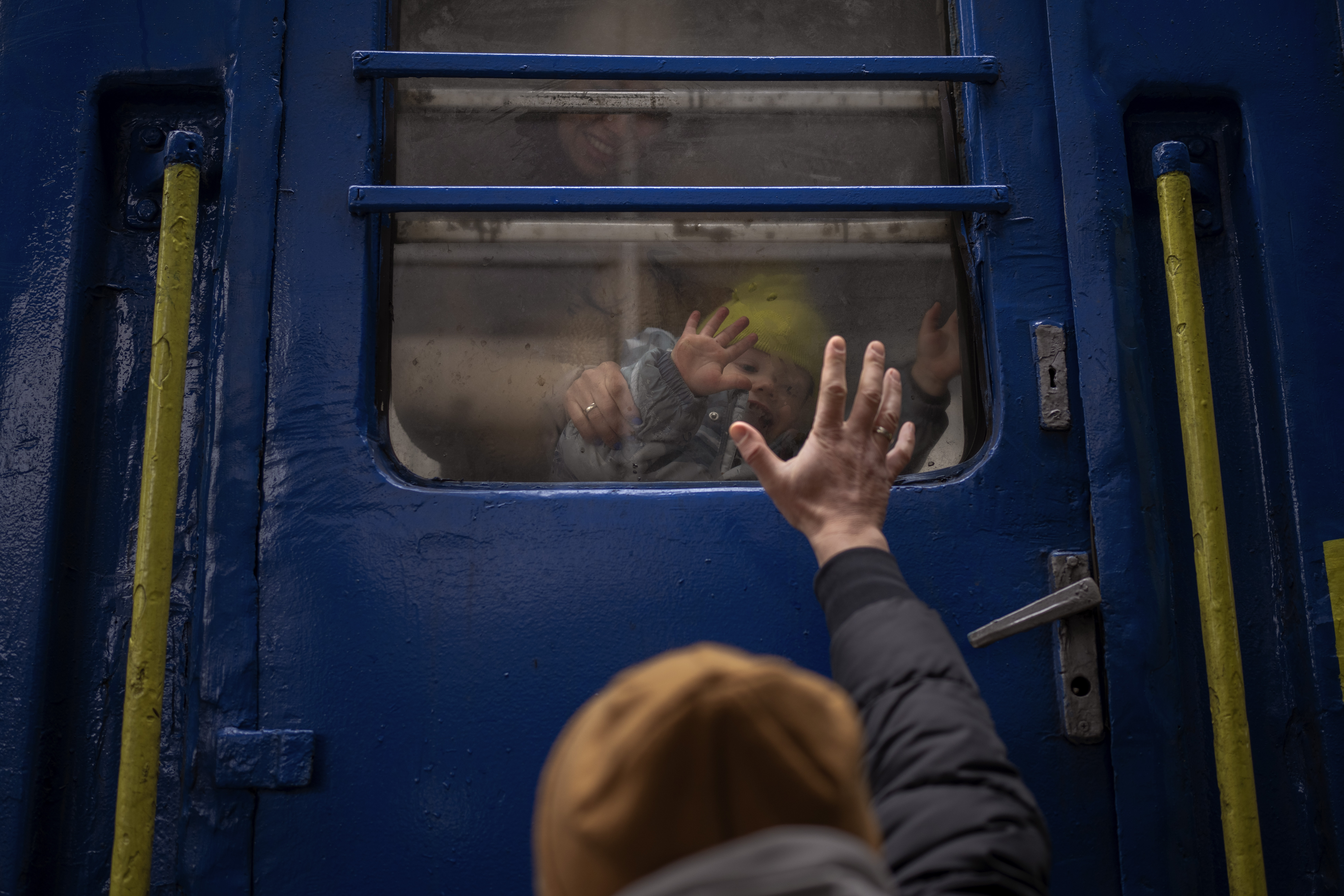 Stanislav says goodbye to his 2-year-old son, David, and wife, Anna, after they boarded a train that will take them to Lviv, from the station in Kyiv