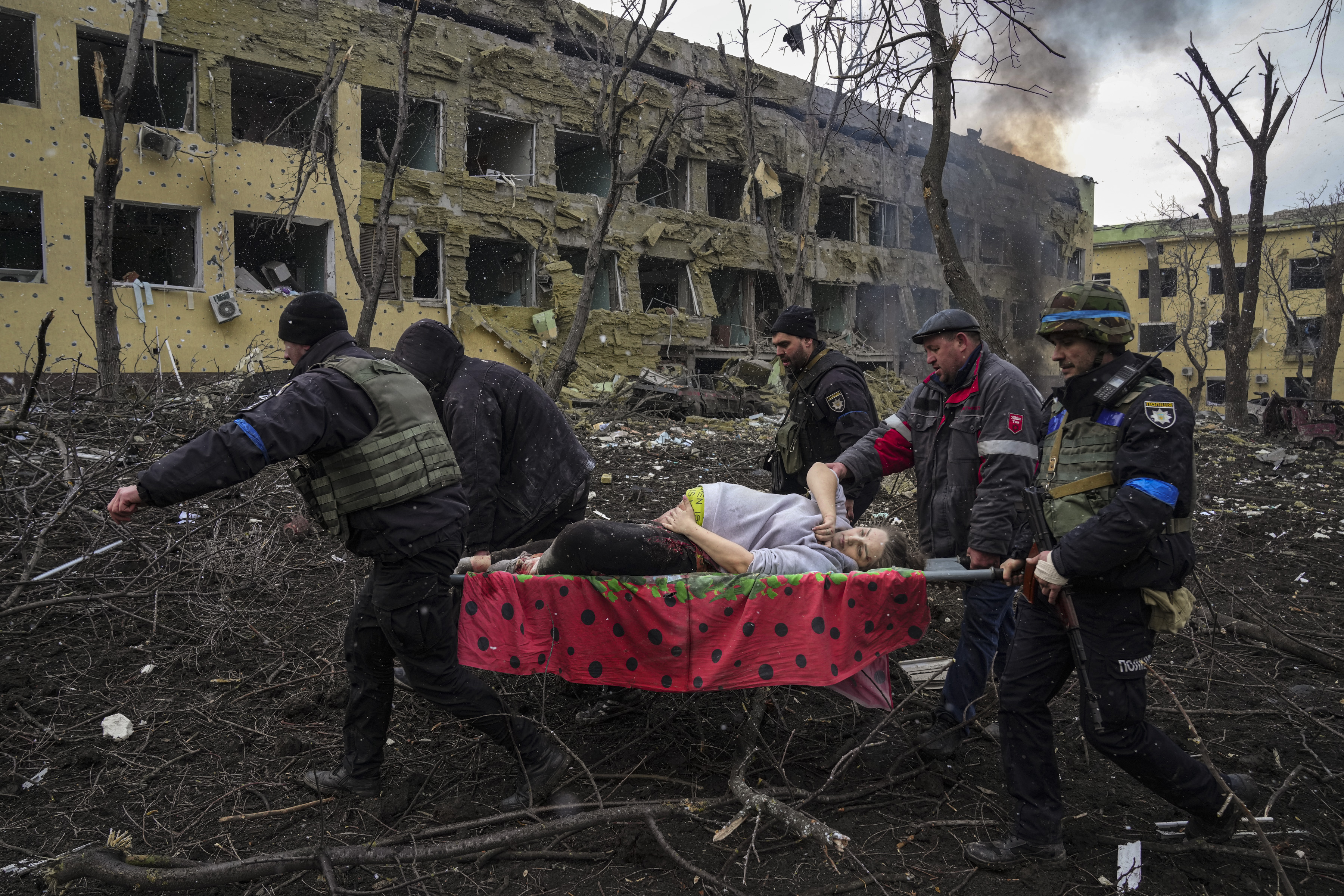Ukrainian emergency personnel and police officers evacuate injured pregnant woman Iryna Kalinina, 32, from a maternity hospital that was damaged by a Russian airstrike in Mariupol