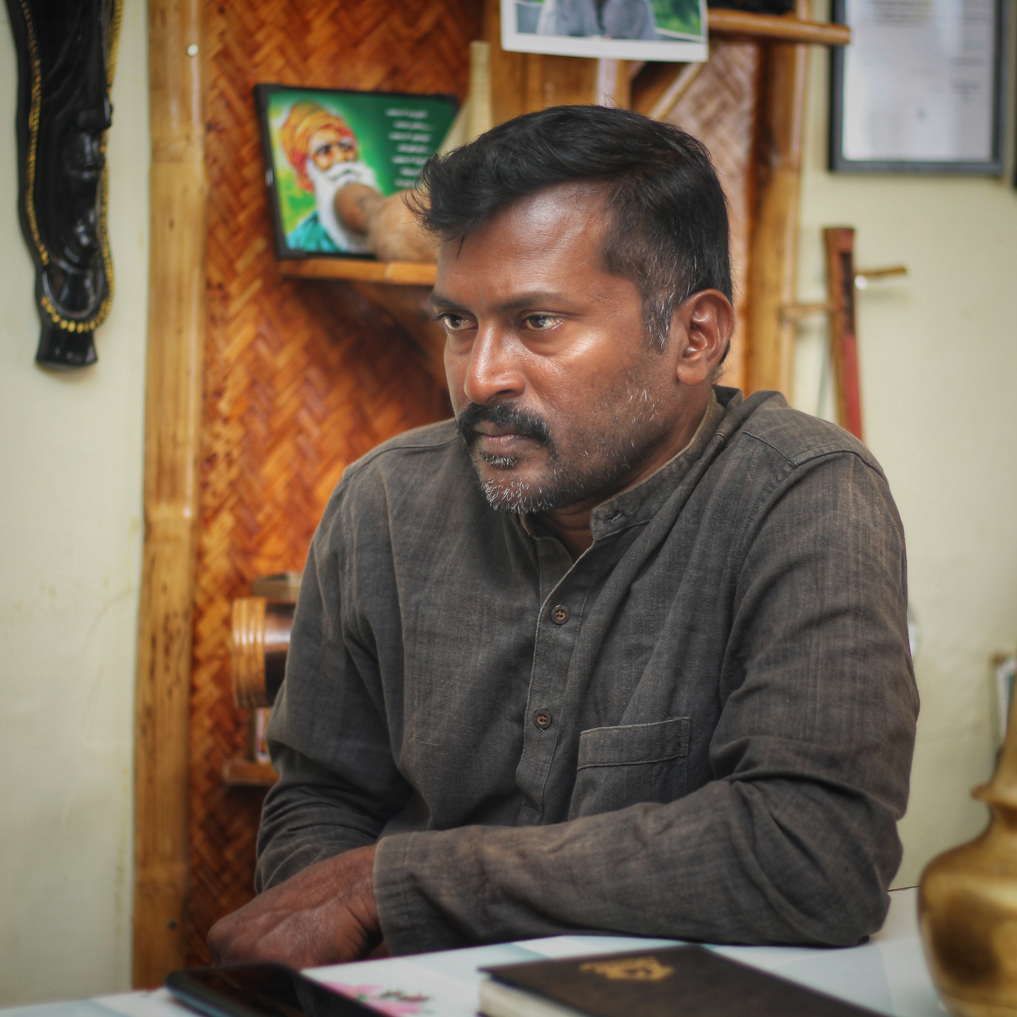 A photo of Anburaj looking to the left.