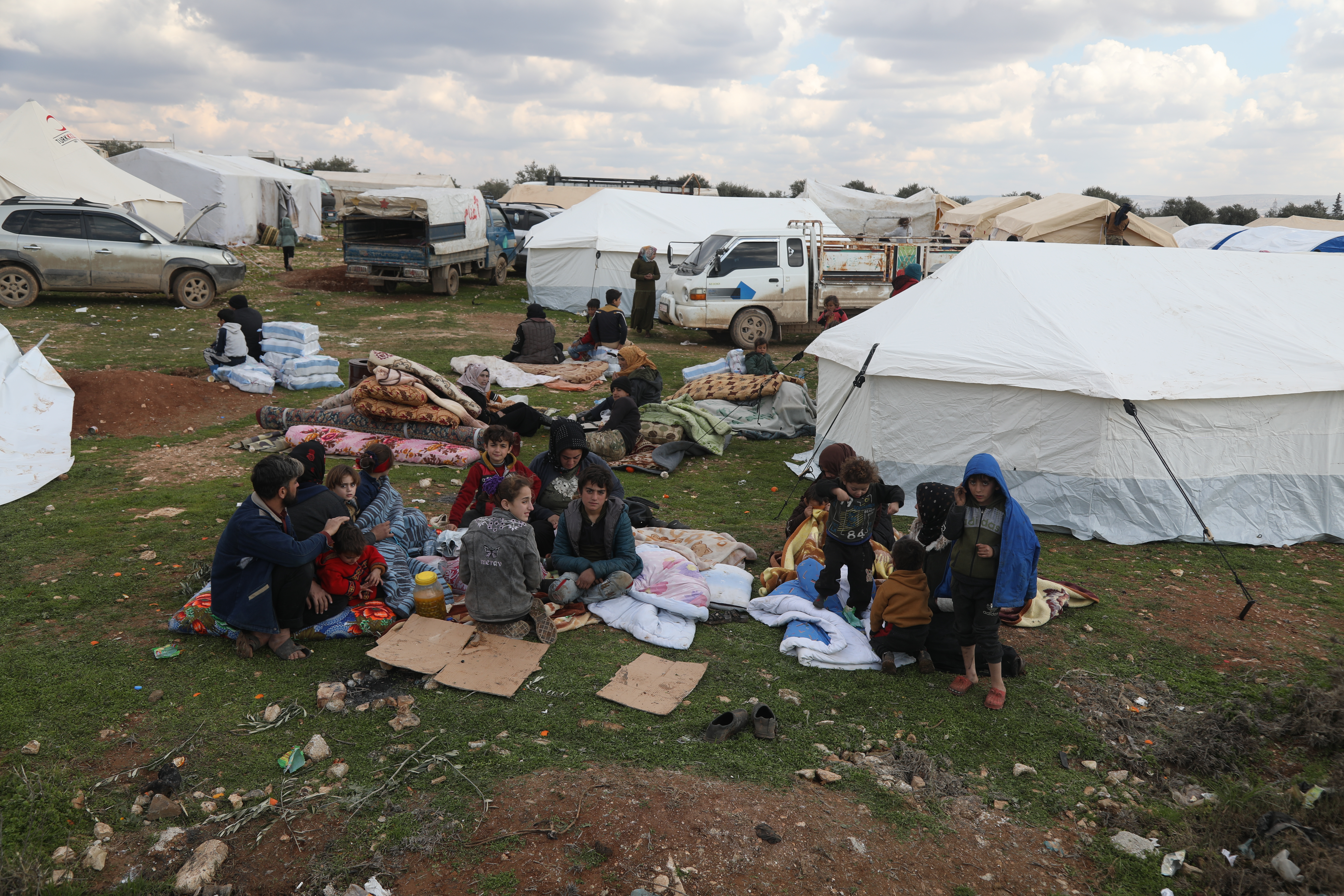 people sitting outside shelter tents