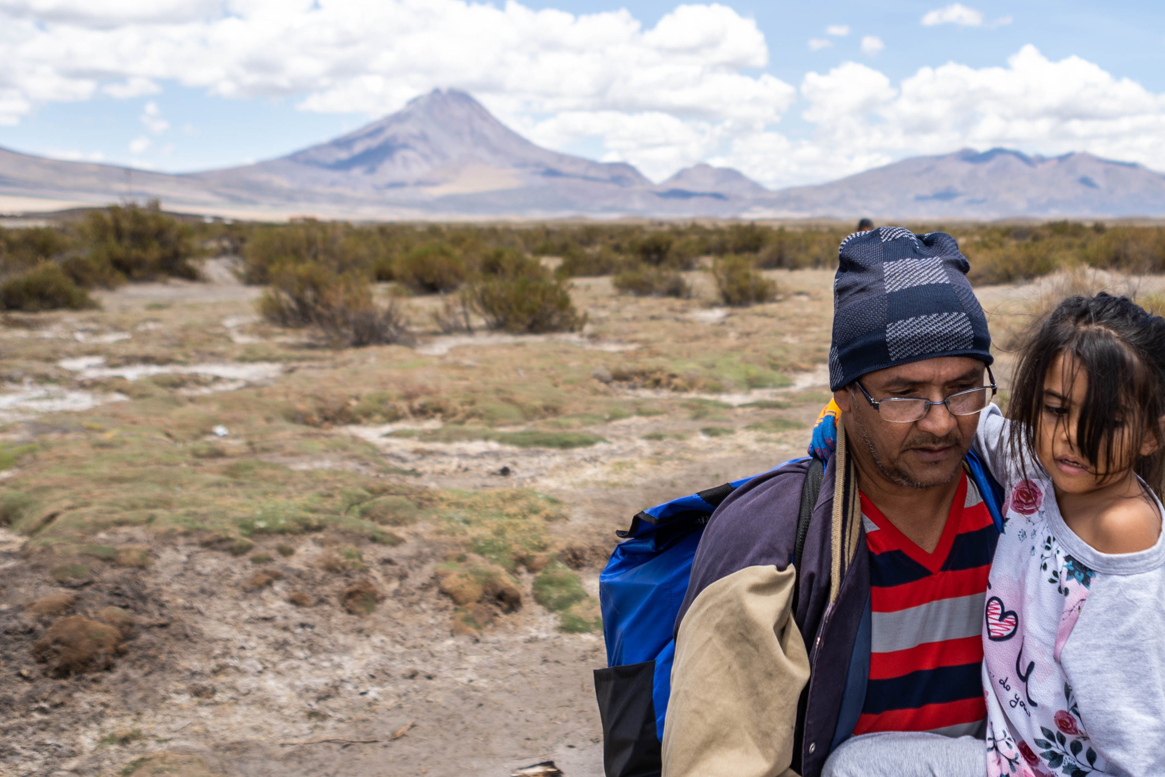 A man carries a 5-year-old girl, Allyson, across the Altiplano highlands.