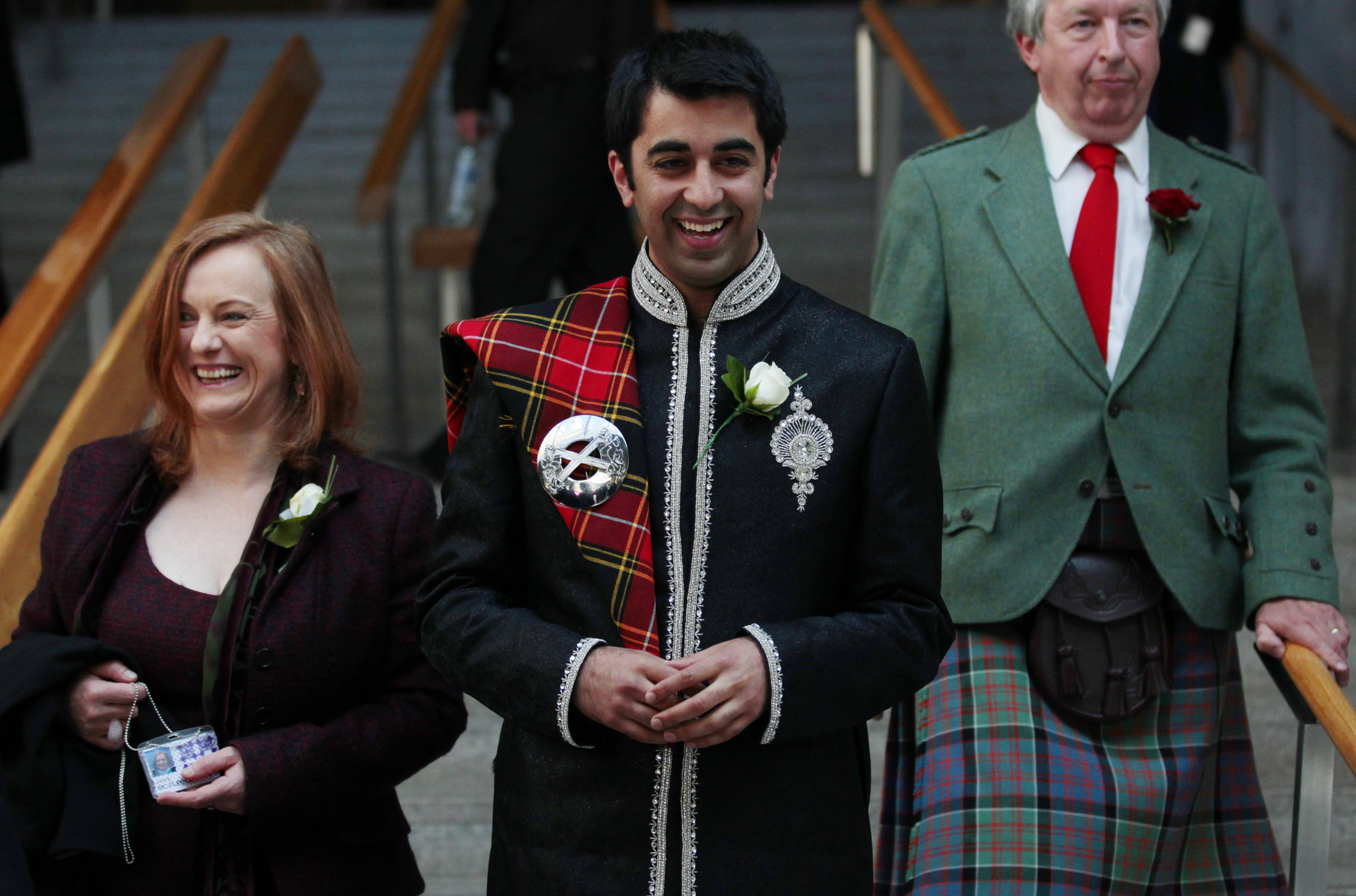 Newly elected Scottish National Party (SNP) Member of Scottish Parliament (MSP) Humza Yousaf (C), smiles as he walks down stairs after the Oath and Affirmation ceremony the Scottish Parliament in Edinburgh, Scotland May 11, 2011. The SNP won sixty nine seats in the Scottish parliament election last week making it the first majority government since devolution began. REUTERS/David Moir (BRITAIN - Tags: POLITICS)