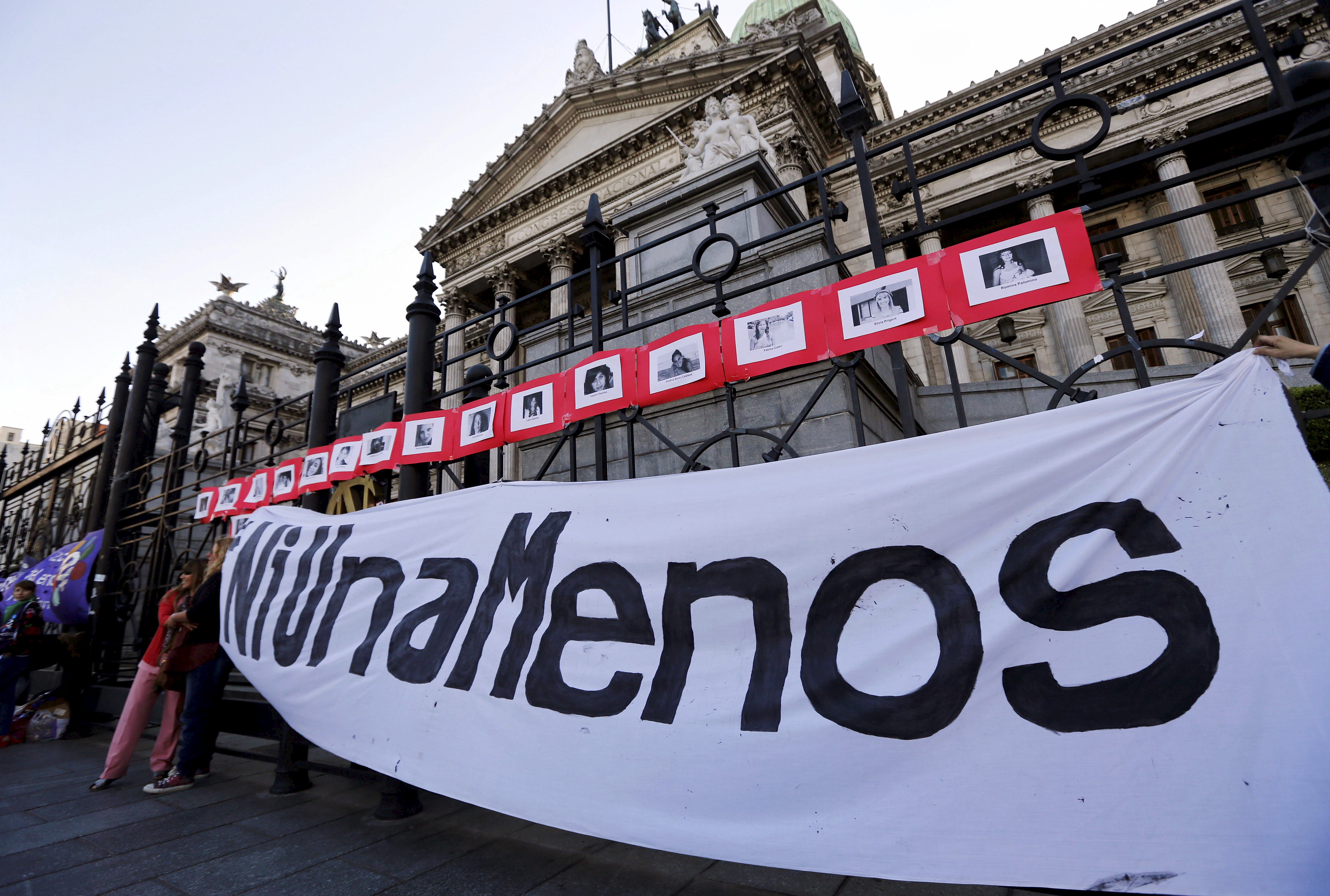 A banner that reads 'Not another (woman) less' is placed on the fence of Argentina's Congress