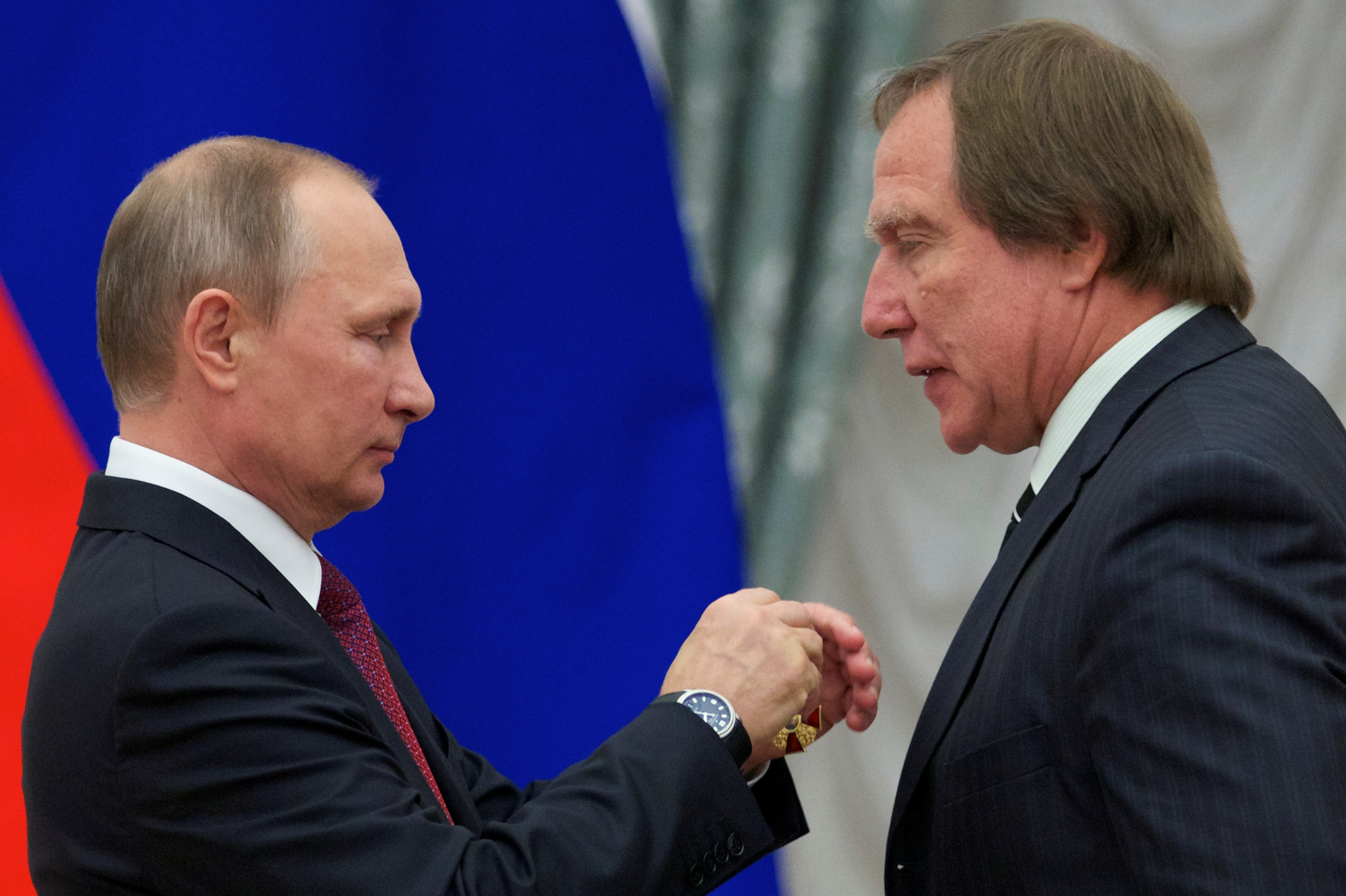 Russian President Vladimir Putin (L) awards artistic director of St. Petersburg House of Music Sergei Roldugin