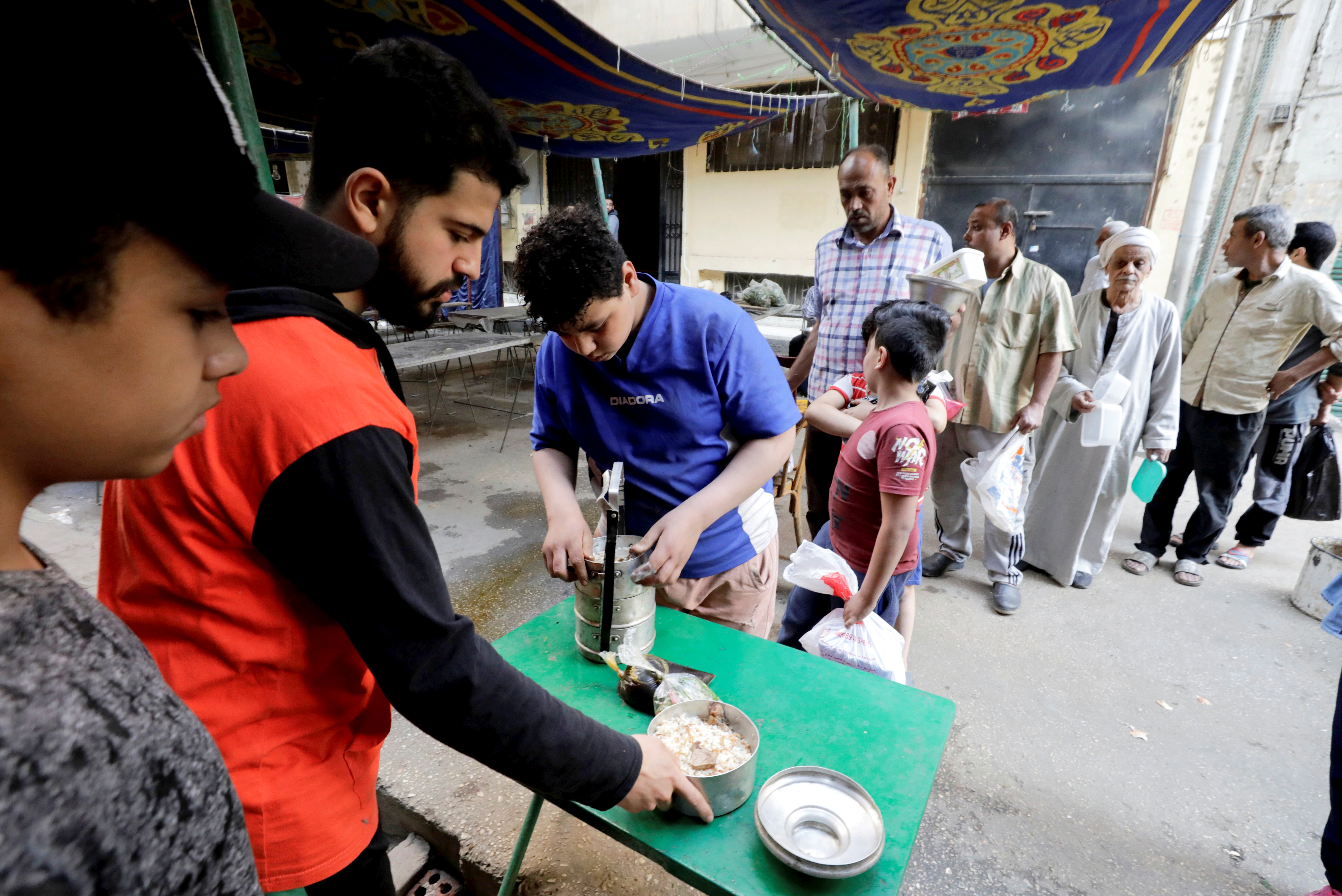People queue to get prepared food to eat during Iftar