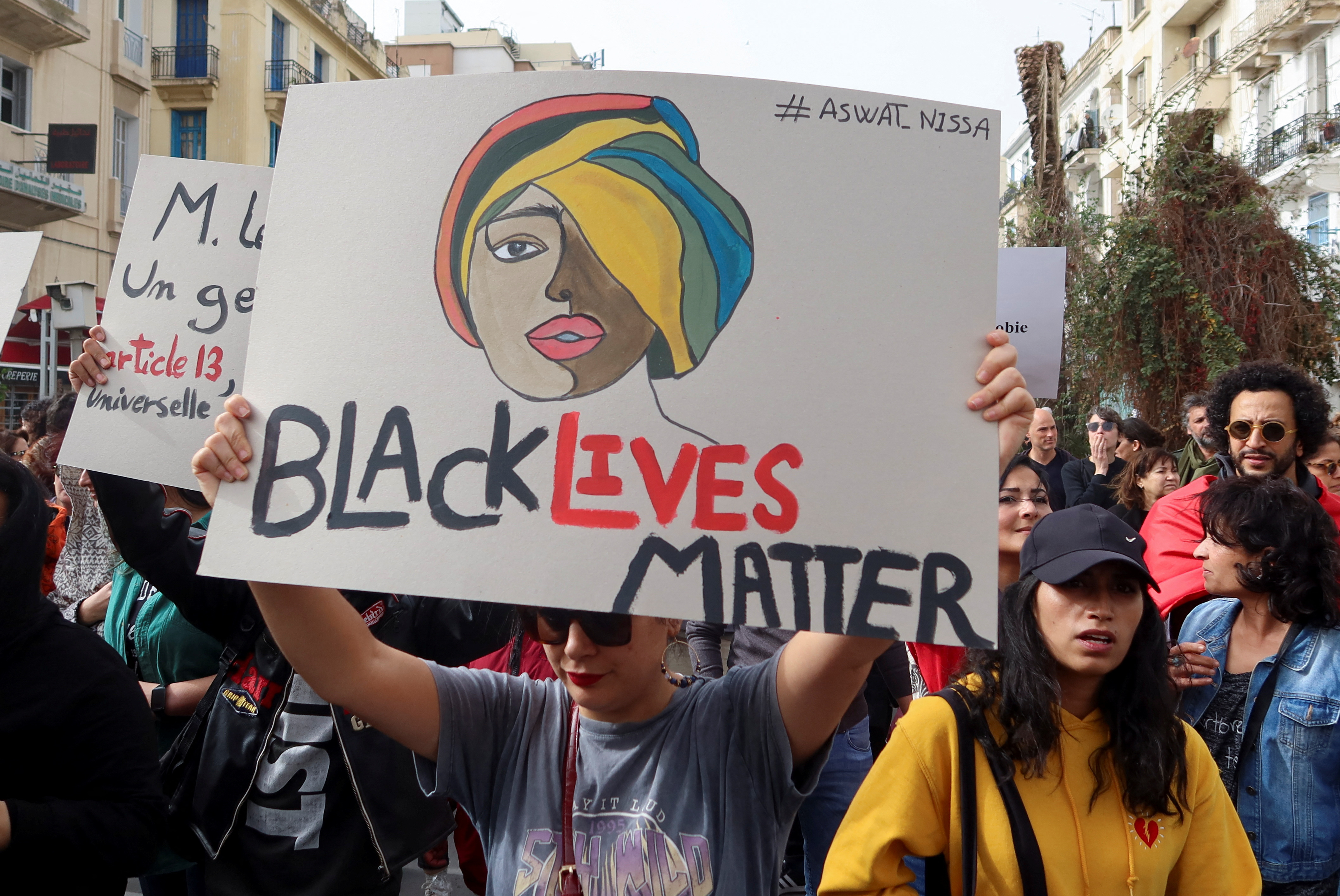 Members of rights groups carry banners during a protest against crackdown on African immigrants.