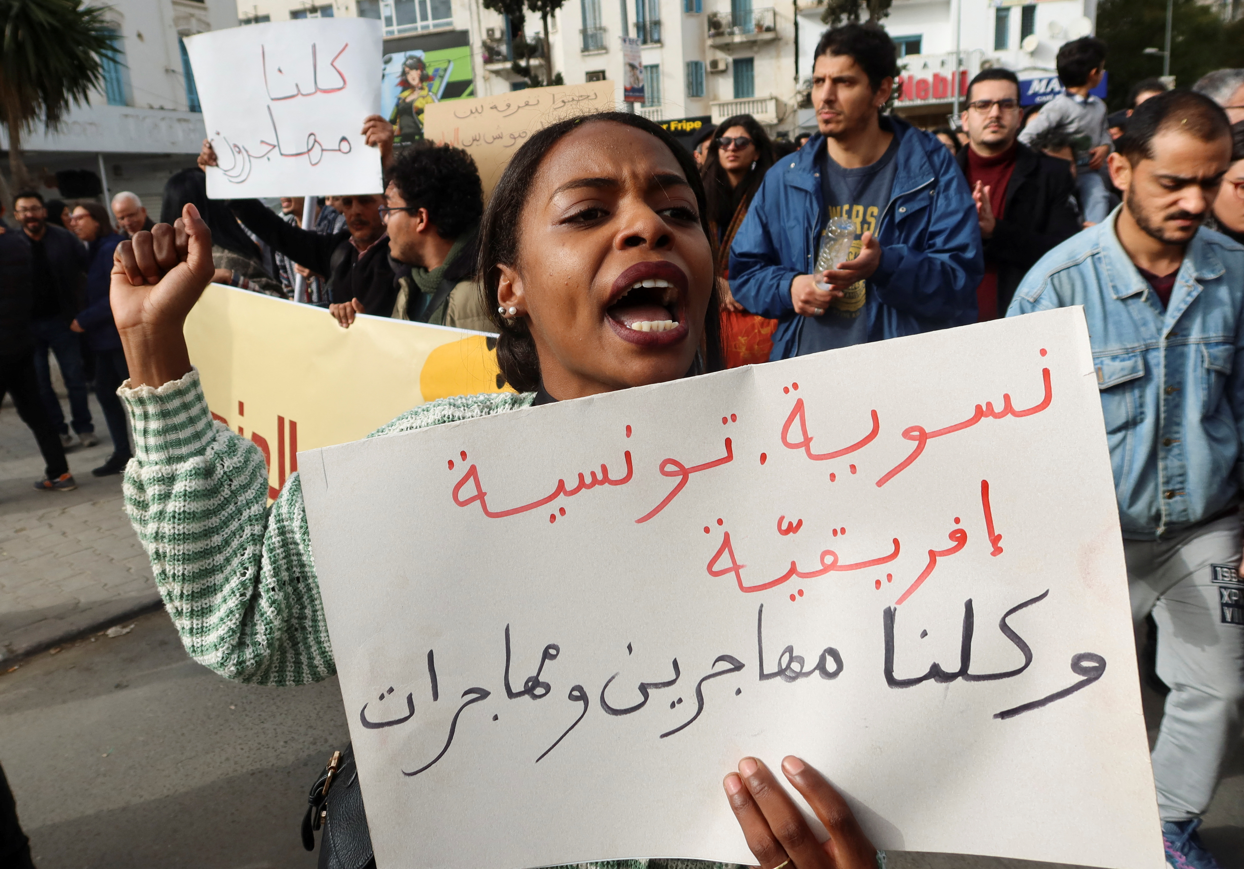 A woman carries a banner, which reads: "Feminist, Tunisian, African. We are all men and women immigrants", during a protest after Tunisian President Kais Saied ordered security forces to stop all illegal migration and expel all undocumented migrants, in Tunis, Tunisia February 25, 2023.