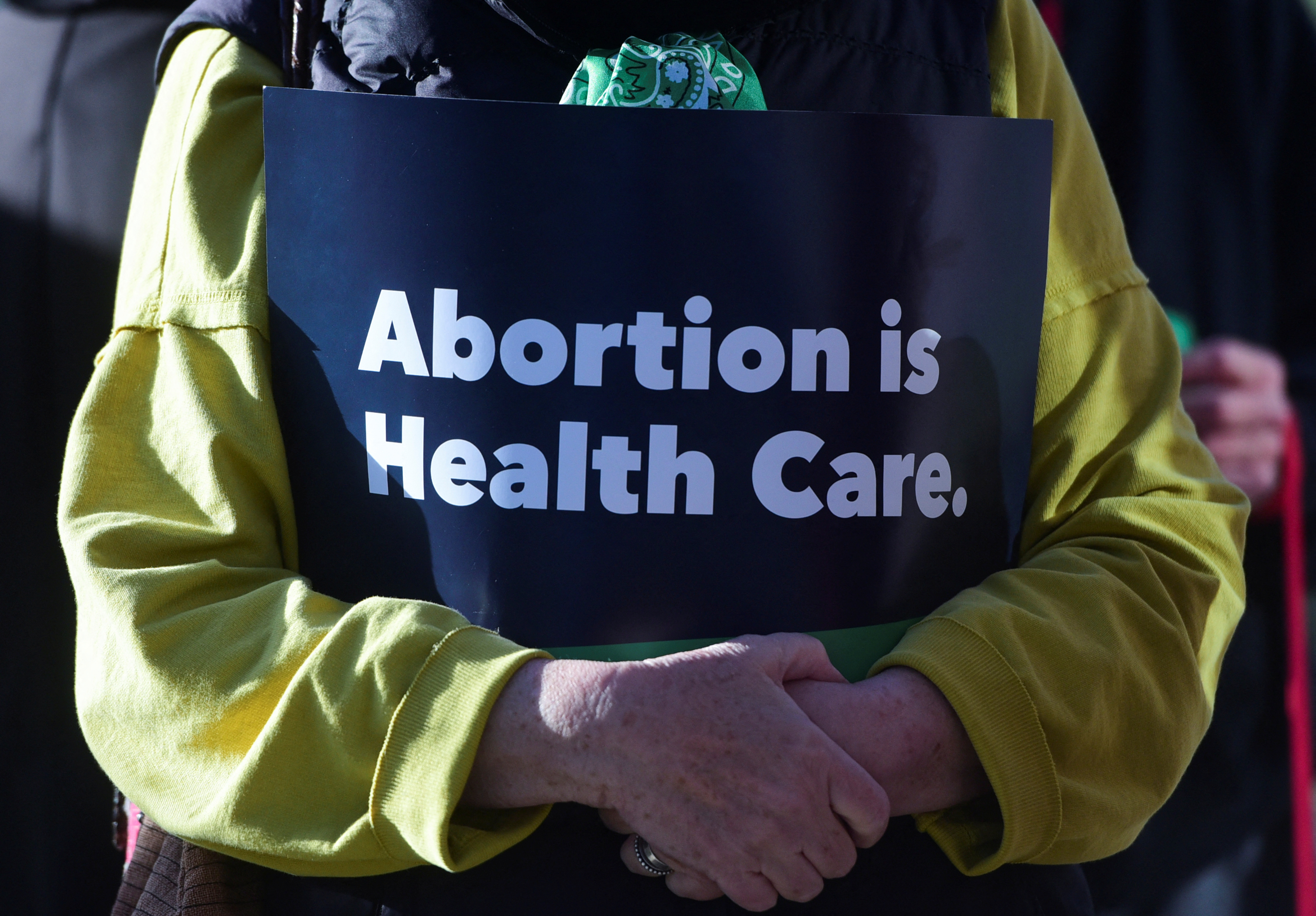 Kathy Thomas holds a “abortion is healthcare” sign during the Women's March protest outside of the Federal Courthouse against U.S. District Judge Matthew Kacsmaryk as he hears a motion by anti-abortion groups led by Alliance for Hippocratic Medicine to pull mifepristone, a drug used in medication abortion, off the market, in Amarillo, Texas, U.S., March 15, 2023. REUTERS/Annie Rice NO RESALES. NO ARCHIVES