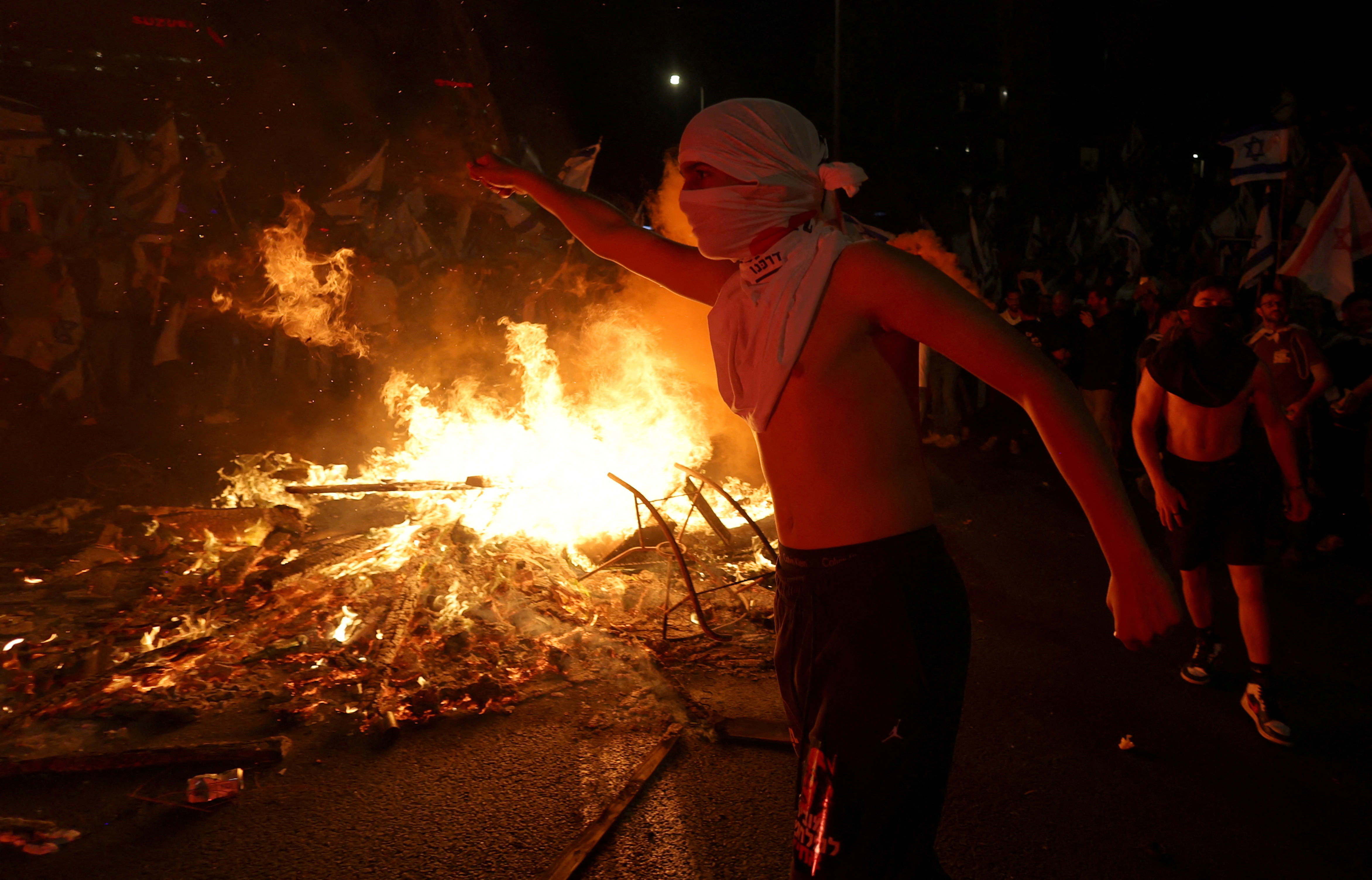 Israeli protesters light a bonfire