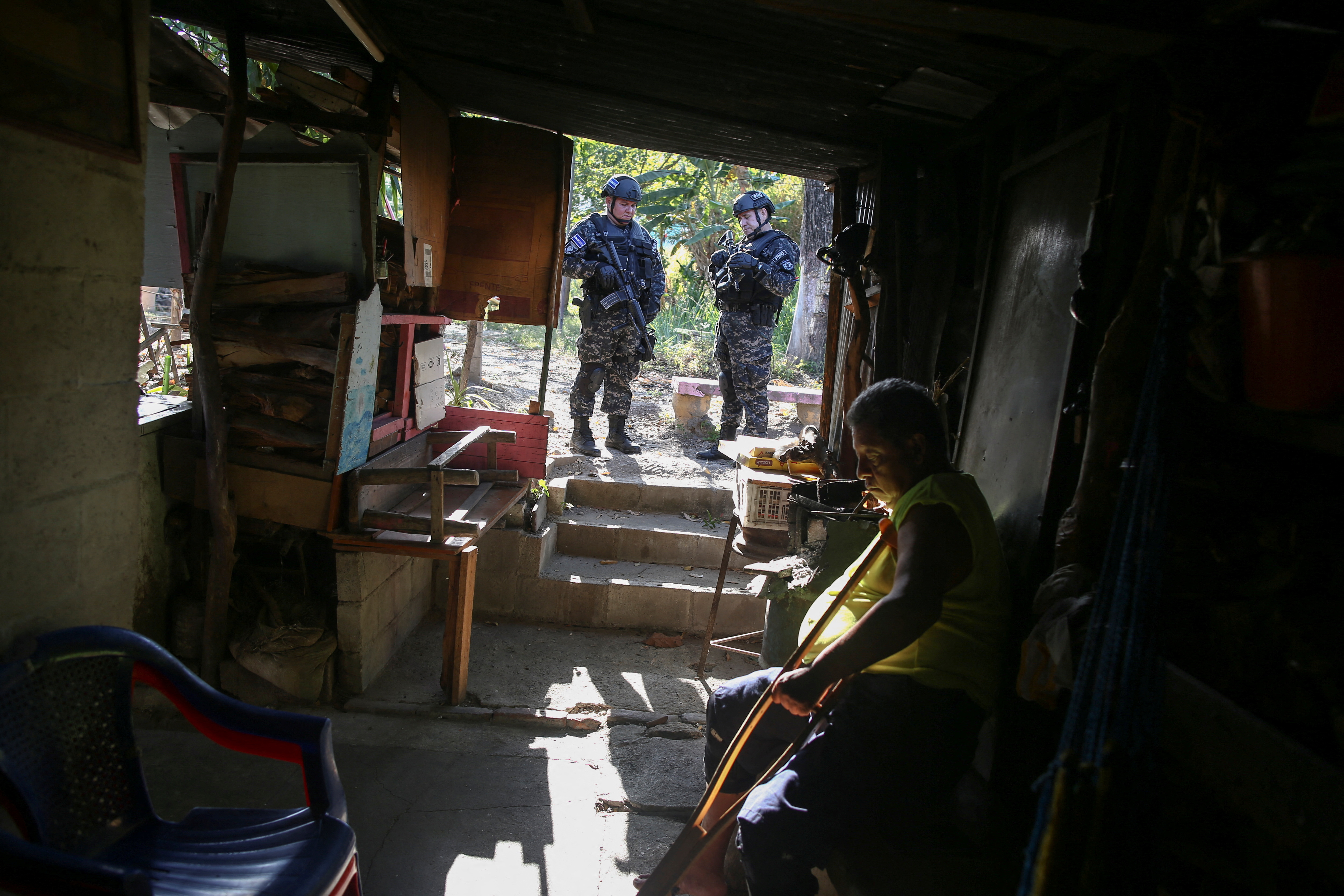 Policemen stand outside a house during an anti-gang patrol at Las Margaritas neighborhood, following a year-long state of emergency against gangs, in Soyapango, El Salvador March 24, 2023. REUTERS/Jose Cabezas