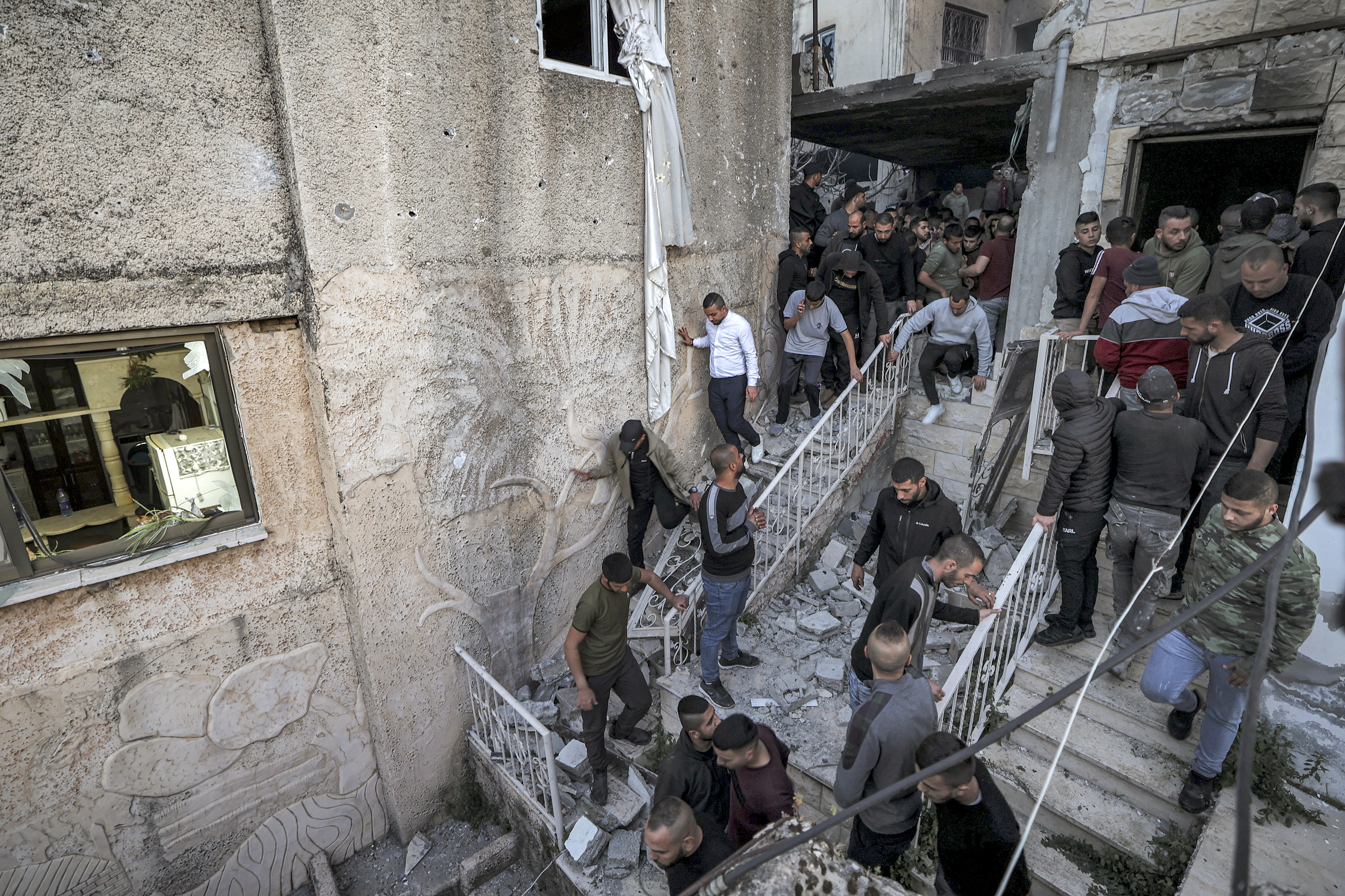 People inspect the wreckage of a building
