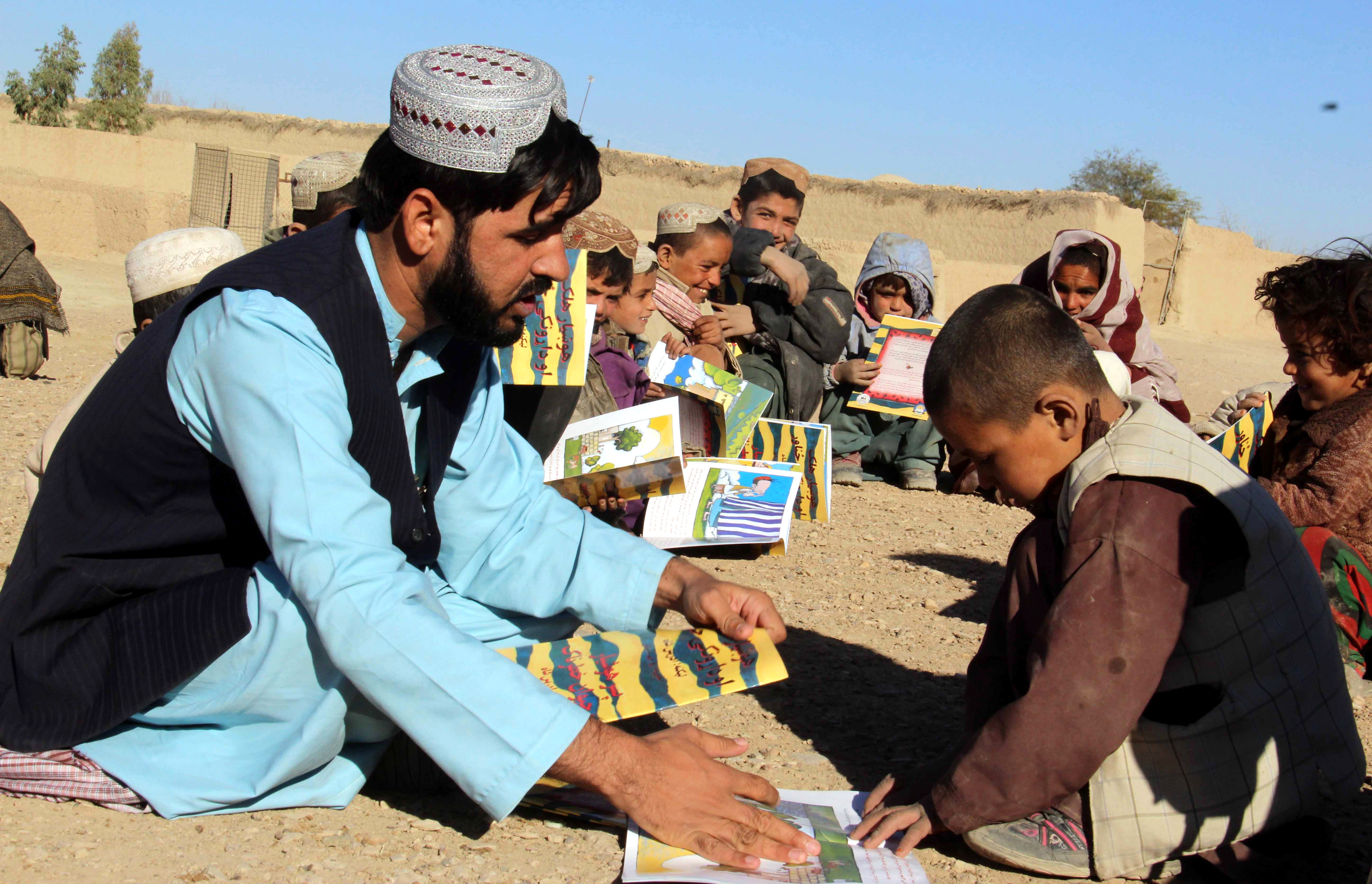 Afghans volunteers of Pen Path Civil Society distribute books during an educational awearness camapign in Kandahar.