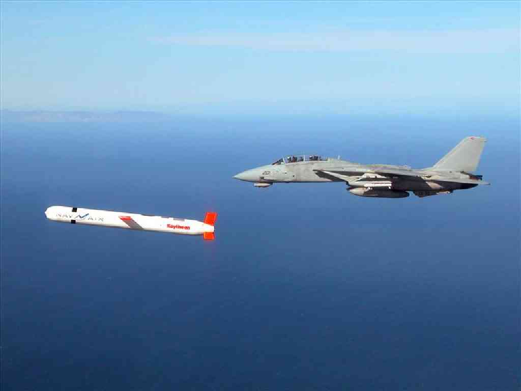US Navy Tactical Tomahawk Block IV cruise missile escorted by F-14 Tomcat fighter jet in flight, photo