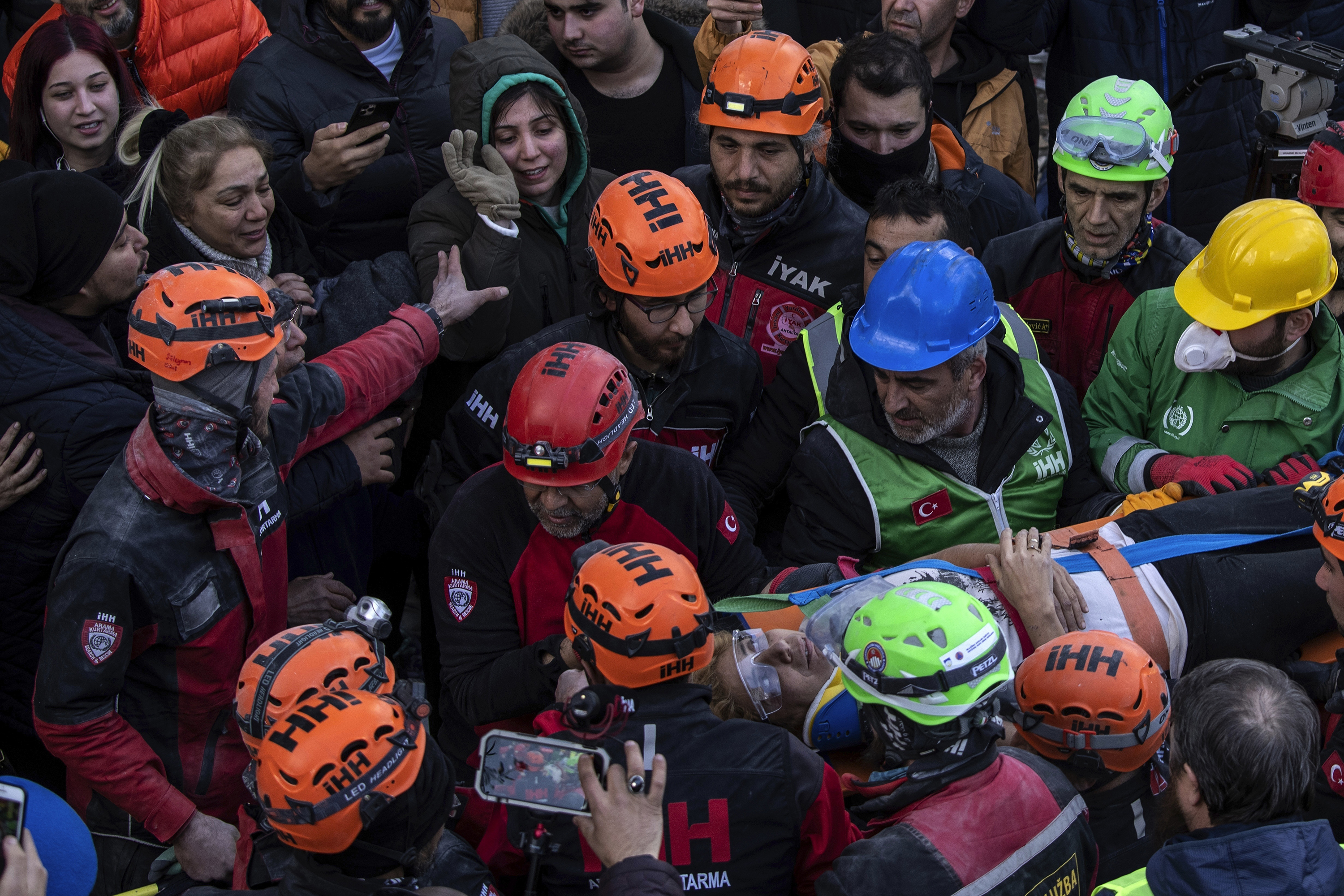Raziye Kilinc is carried through a crowd on a stretcher after she was rescued under a destroyed building as her daughter