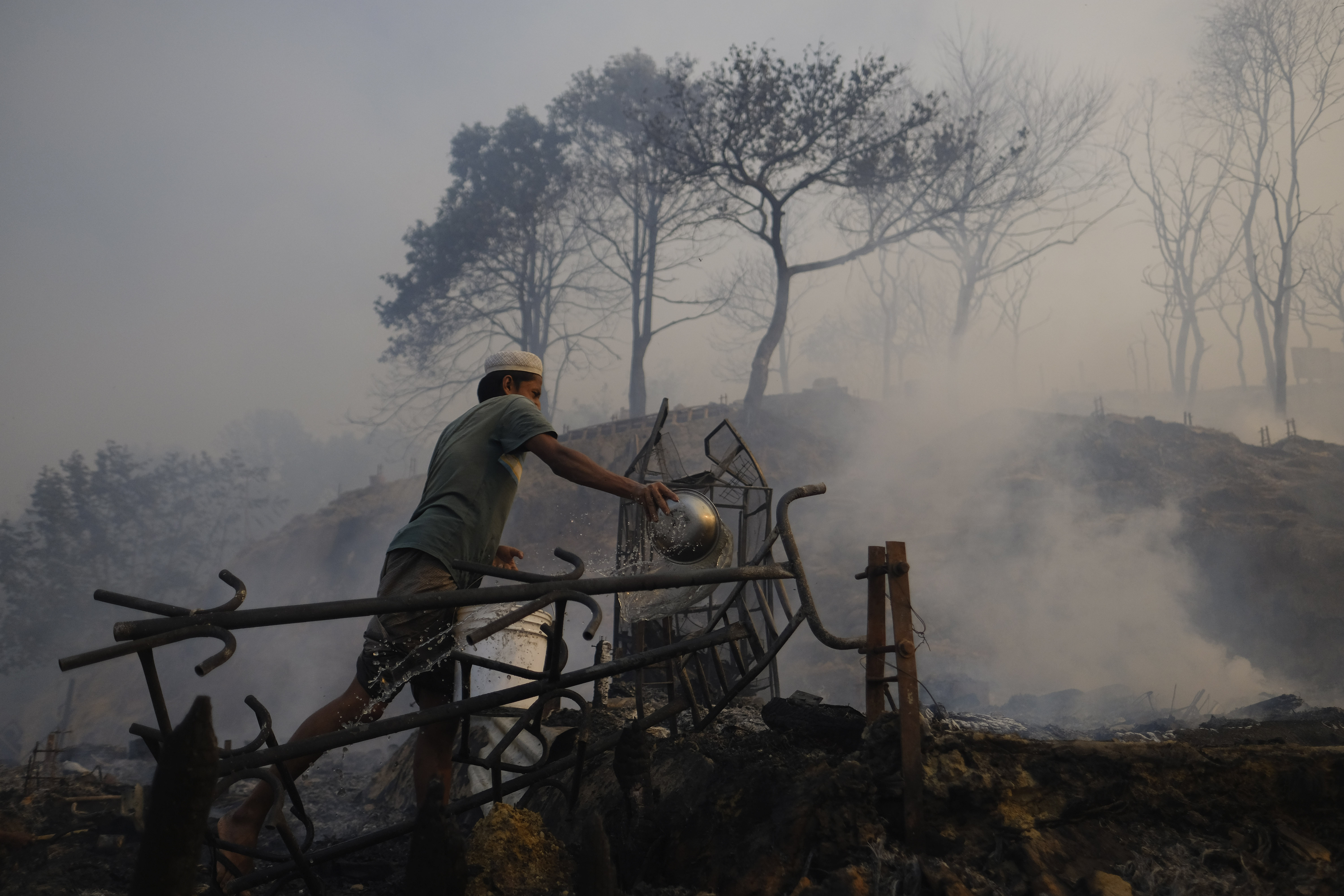Rohingya refugees try to salvage their belongings after a major fire in their Balukhali camp at Ukhiya in Cox's Bazar district, Bangladesh