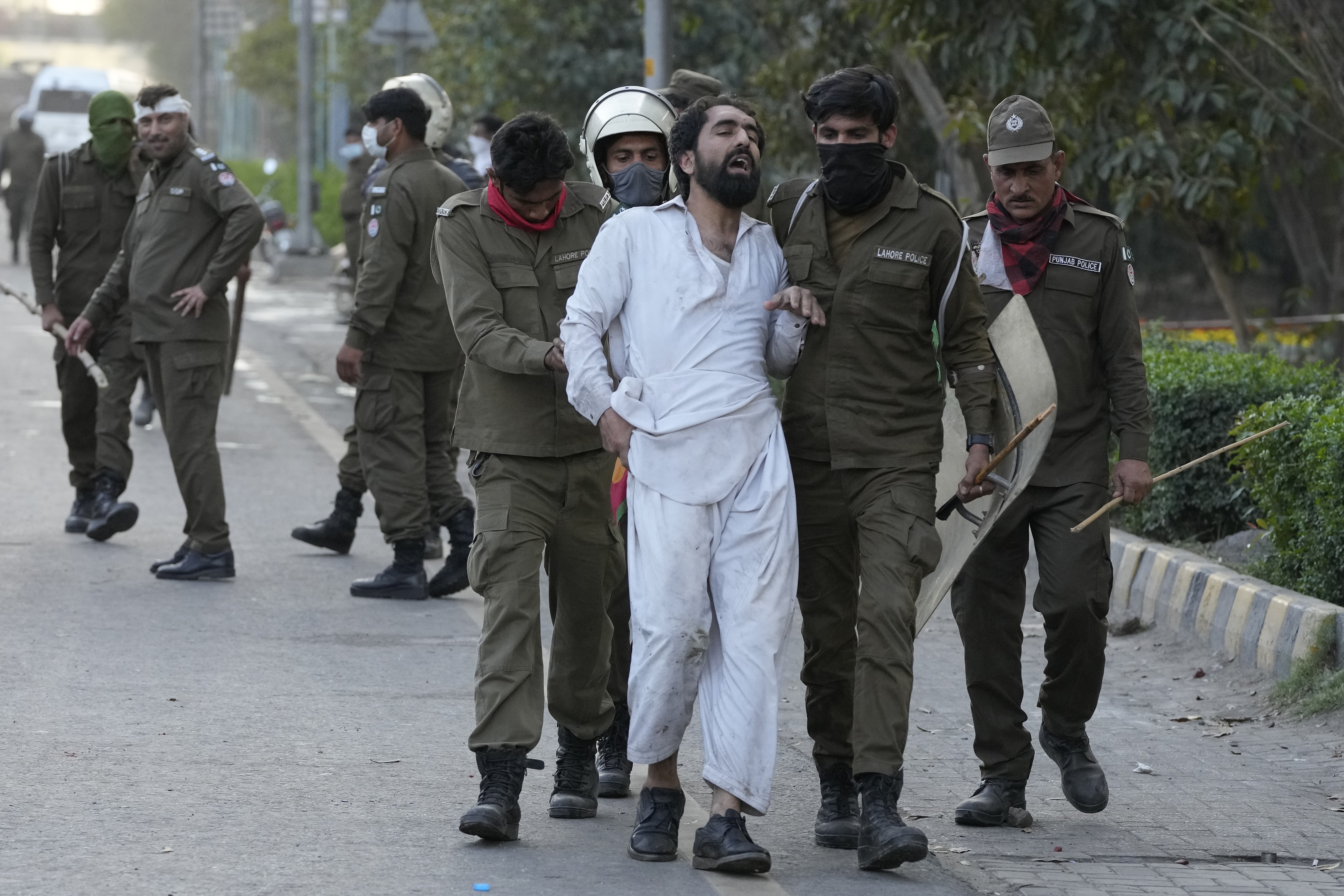 Police officers detain a supporter of Pakistan's former Prime Minister Imran Khan in Lahore.