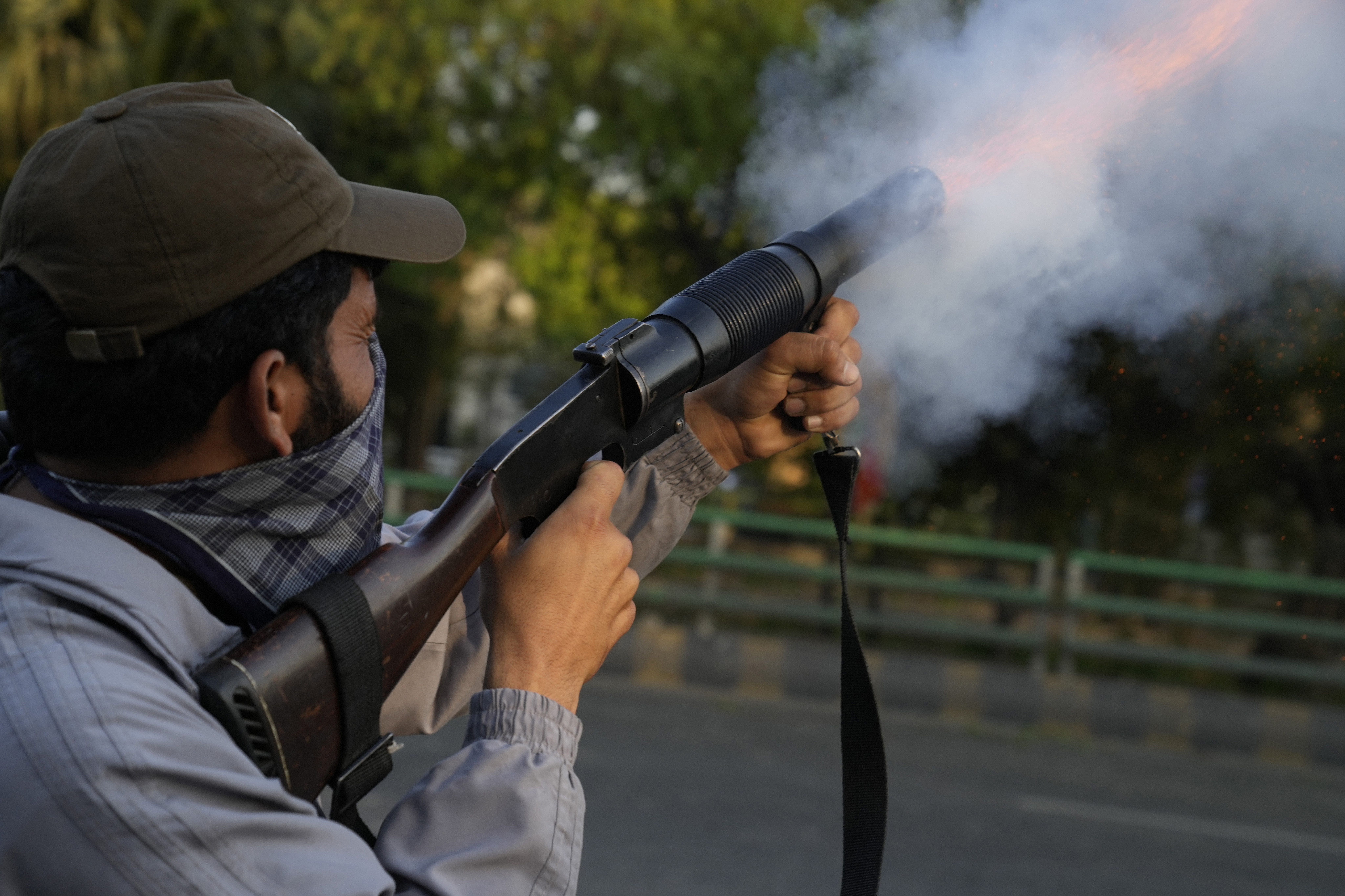 A police officer fires tear gas shell to disperse the supporters of Pakistan's former Prime Minister Imran Khan in Lahore.