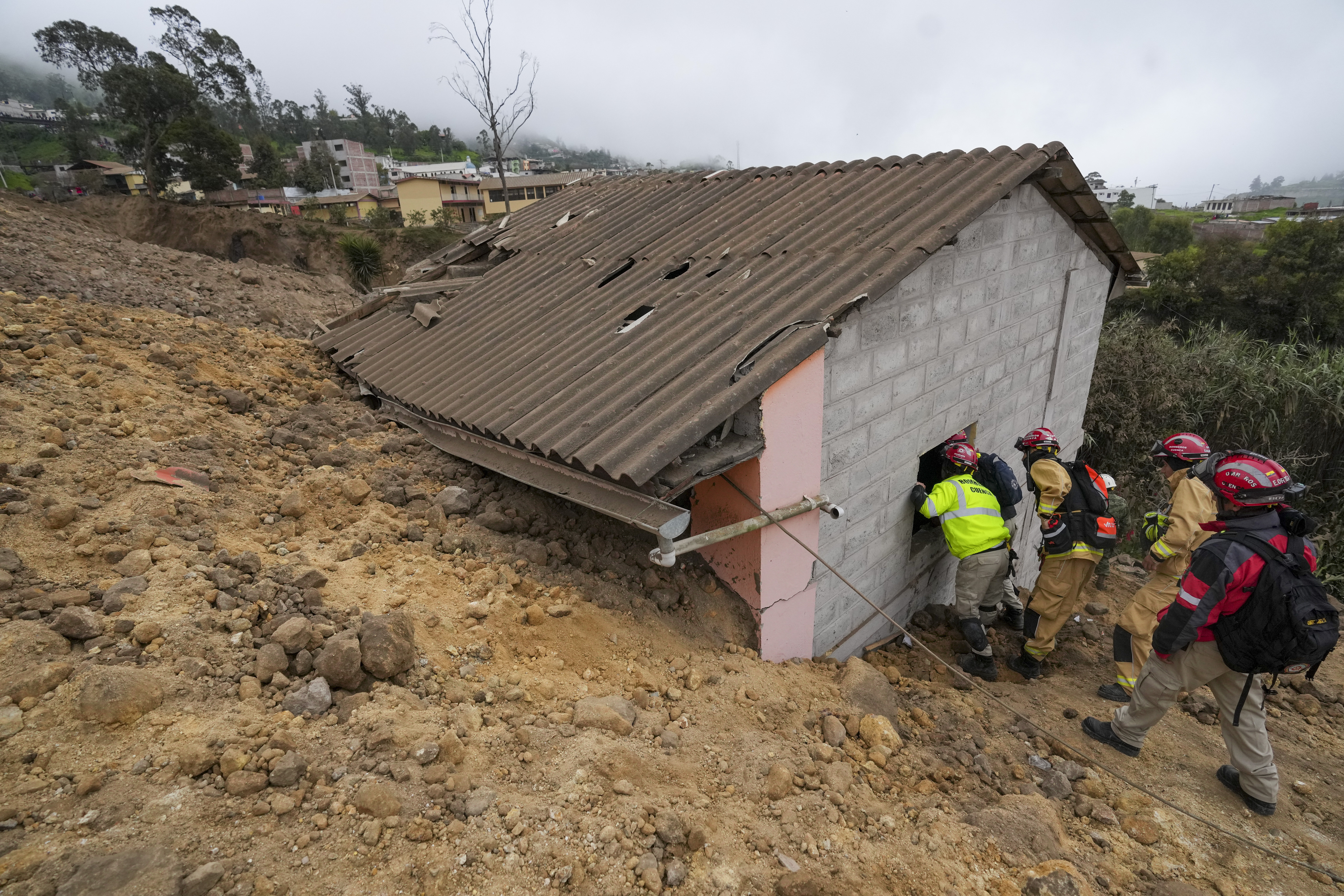 Rescue workers inspect a house destroyed by a deadly landslide that buried dozens of homes in Alausi, Ecuador