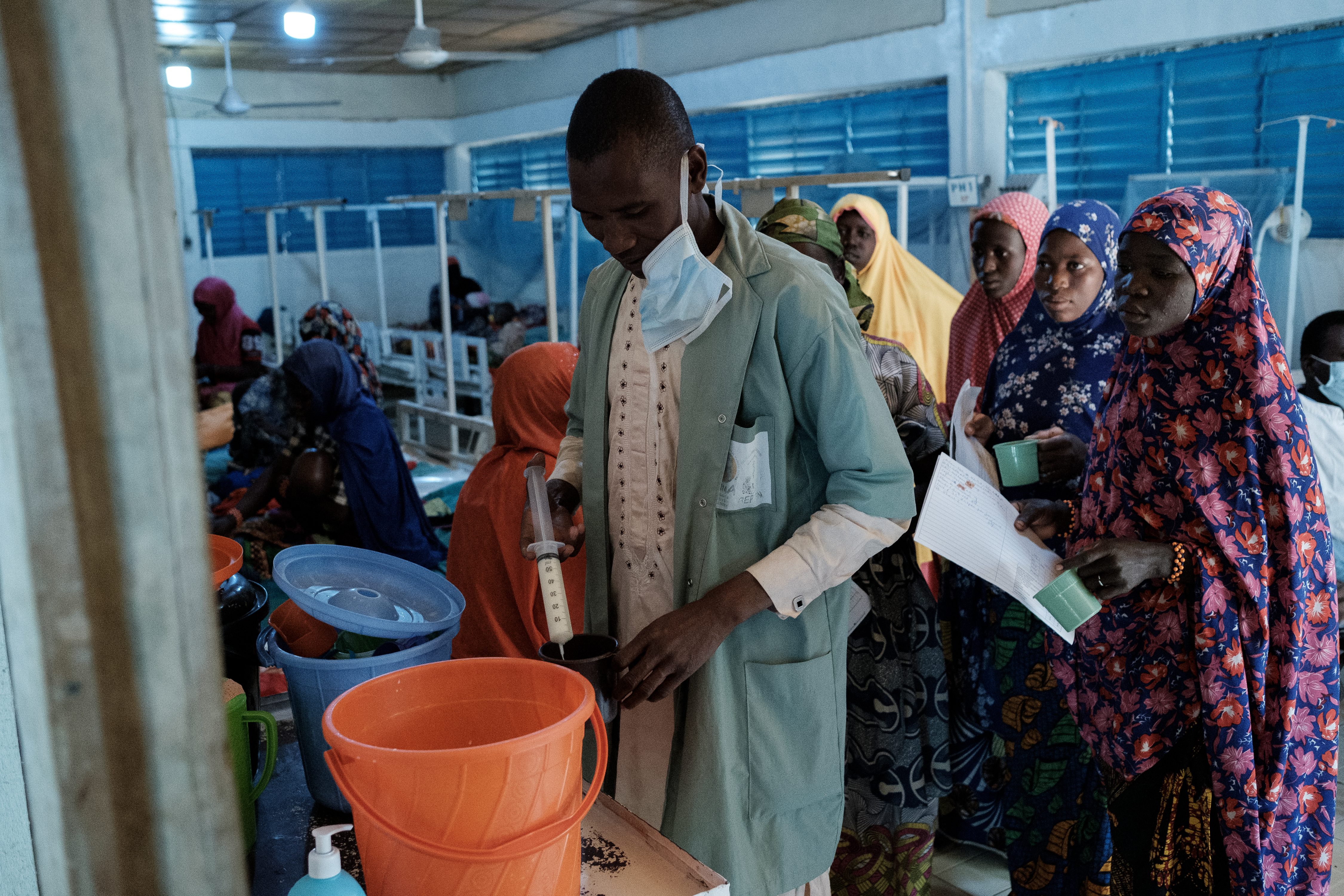 A nurse uses a syringe to fill feeding cups for infants who are being treated for Malnutrition at Aguia Clinic in Southern Niger