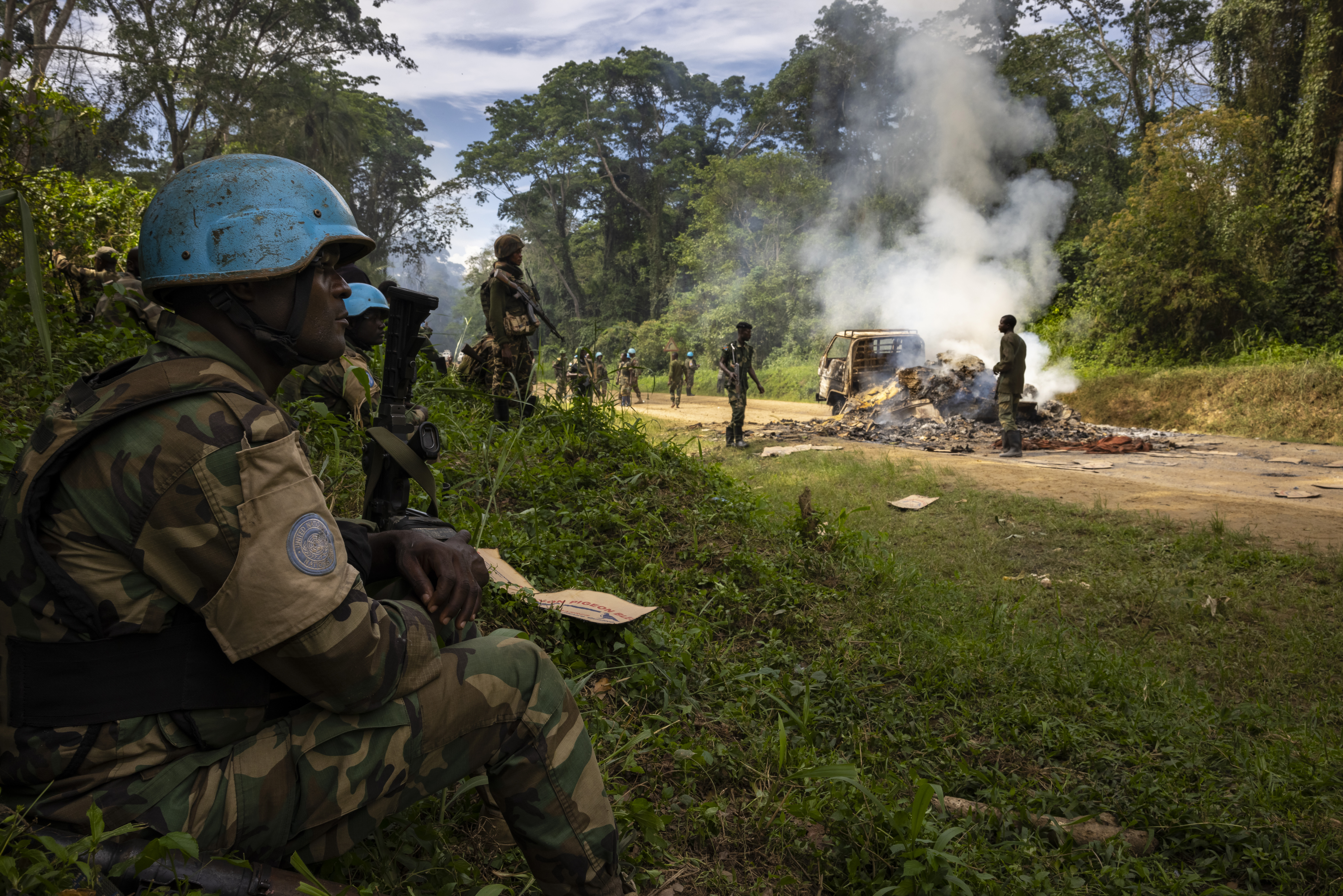 KILYA, RWENZORI SECTOR, DEMOCRATIC REPUBLIC OF THE CONGO - APRIL 09: Congolese Army Soldiers and UN troops inspect an ambush site where an hour previously ADF fundamentalist rebels attacked two vehicles on the road between Beni and the Ugandan border town of Kasindi, on April 9, 2021 in Kilya, Rwenzori Sector, Democratic Republic of the Congo. ADF killed three civilians in the vehicles, assassinating them with shots to the head outside of their vehicles, there was also evidence of cuts from machetes. The Malawian contingent of the UN’s MONUSCO force arrived on scene as the ambush was ending and the vehicles were being set on fire. They engaged a large force of ADF fighters, killing one of them. That fighter was stripped of his uniform by other ADF fighters during the firefight, they then fled into the jungle. The purpose of the ADF’s attacks is to spread terror amongst the civilian population. There have been multiple attacks across the province by ADF, all characterized by brutality and on occasion, beheadings. The ADF is an Islamic terror group based out of Eastern DR Congo that, in recent years, has developed a relationship with the Islamic State after pledging allegiance to ISIS leadership. They are known locally as ISIS in Congo.