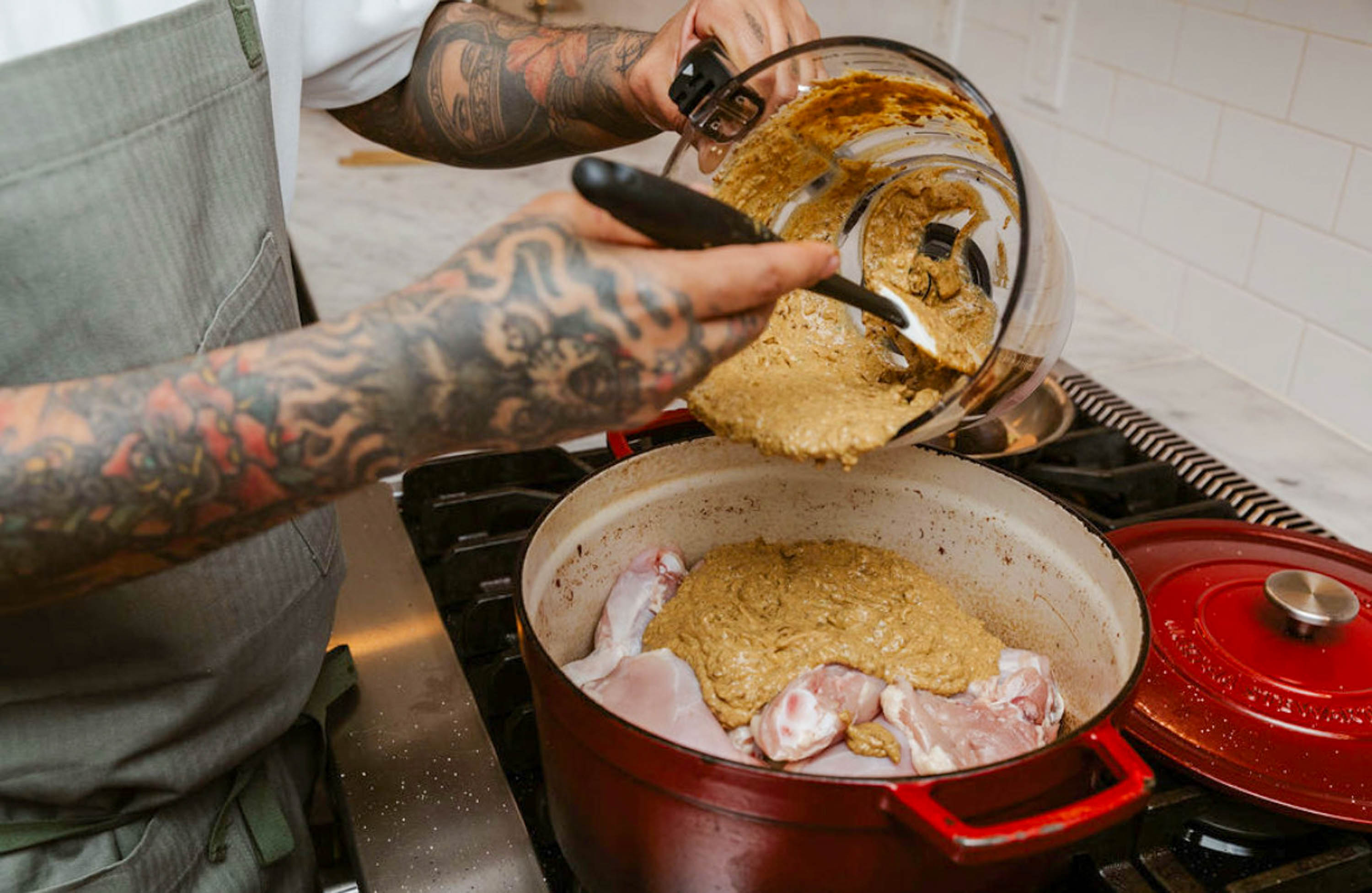 Akram Said putting marinade on raw chicken in a pot