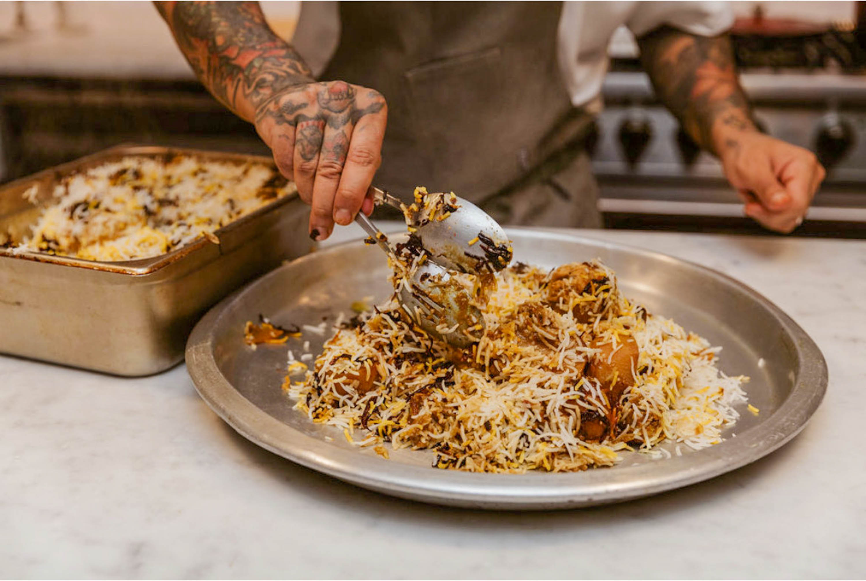 Akram serving the chicken zorbiyan on a plate