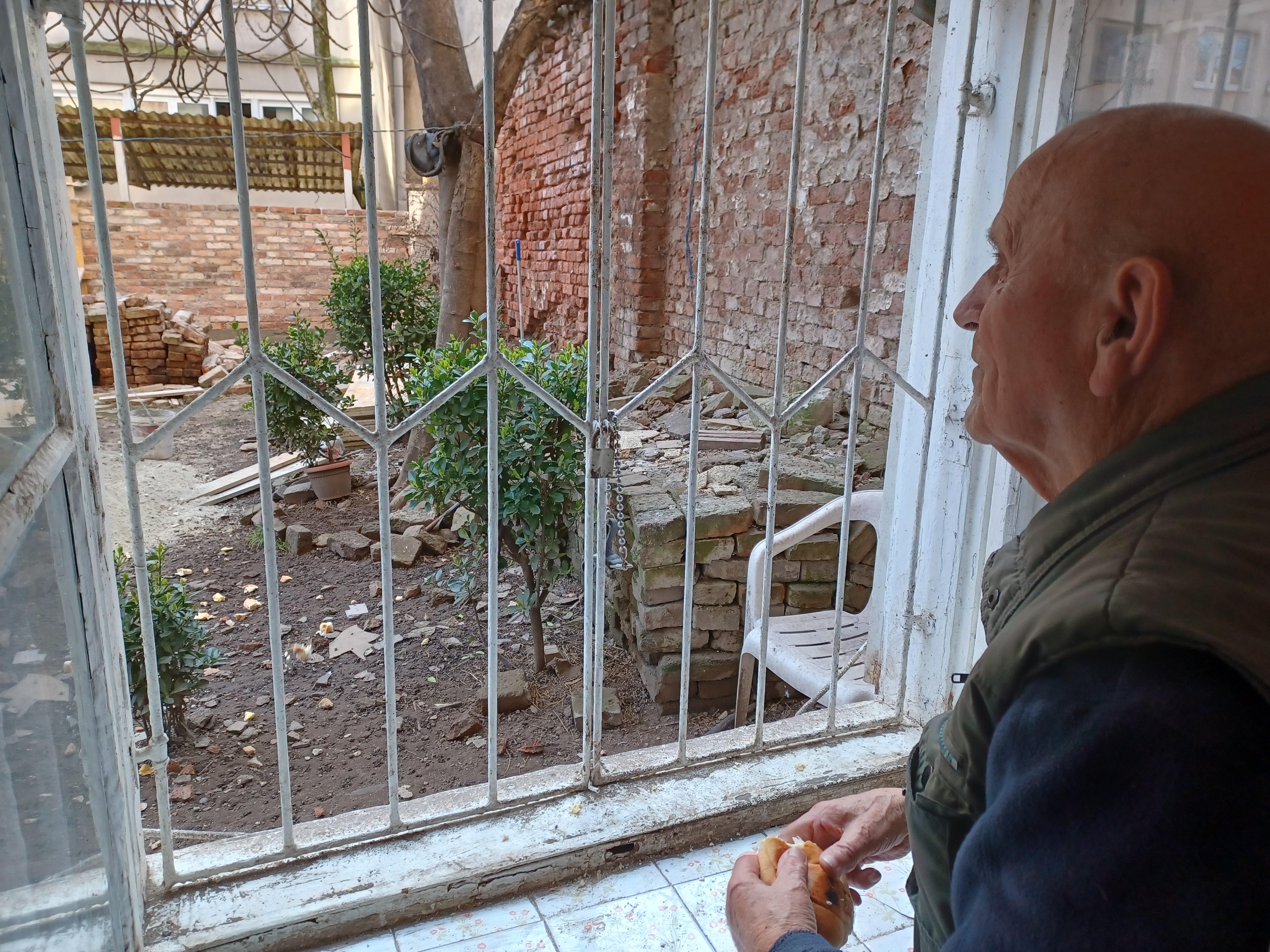 A photo of Ivan Capan looking through a window from the inside.