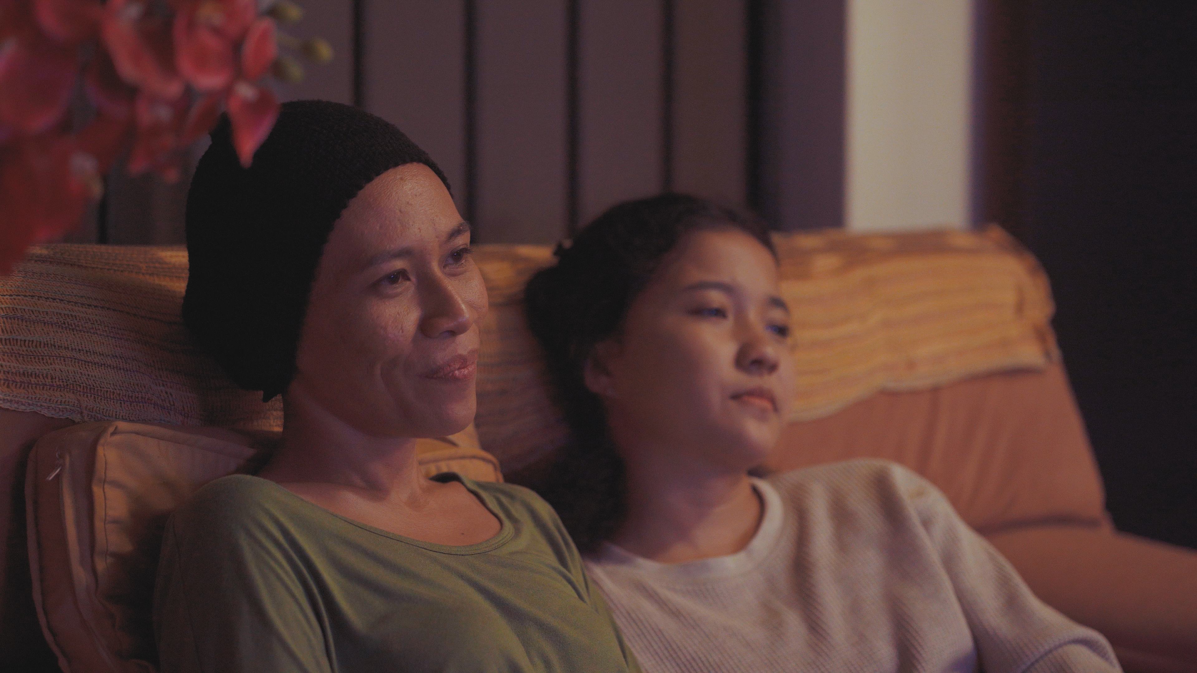 A still from the film Mentega Terbang showing mother and daughter relaxing on the sofa