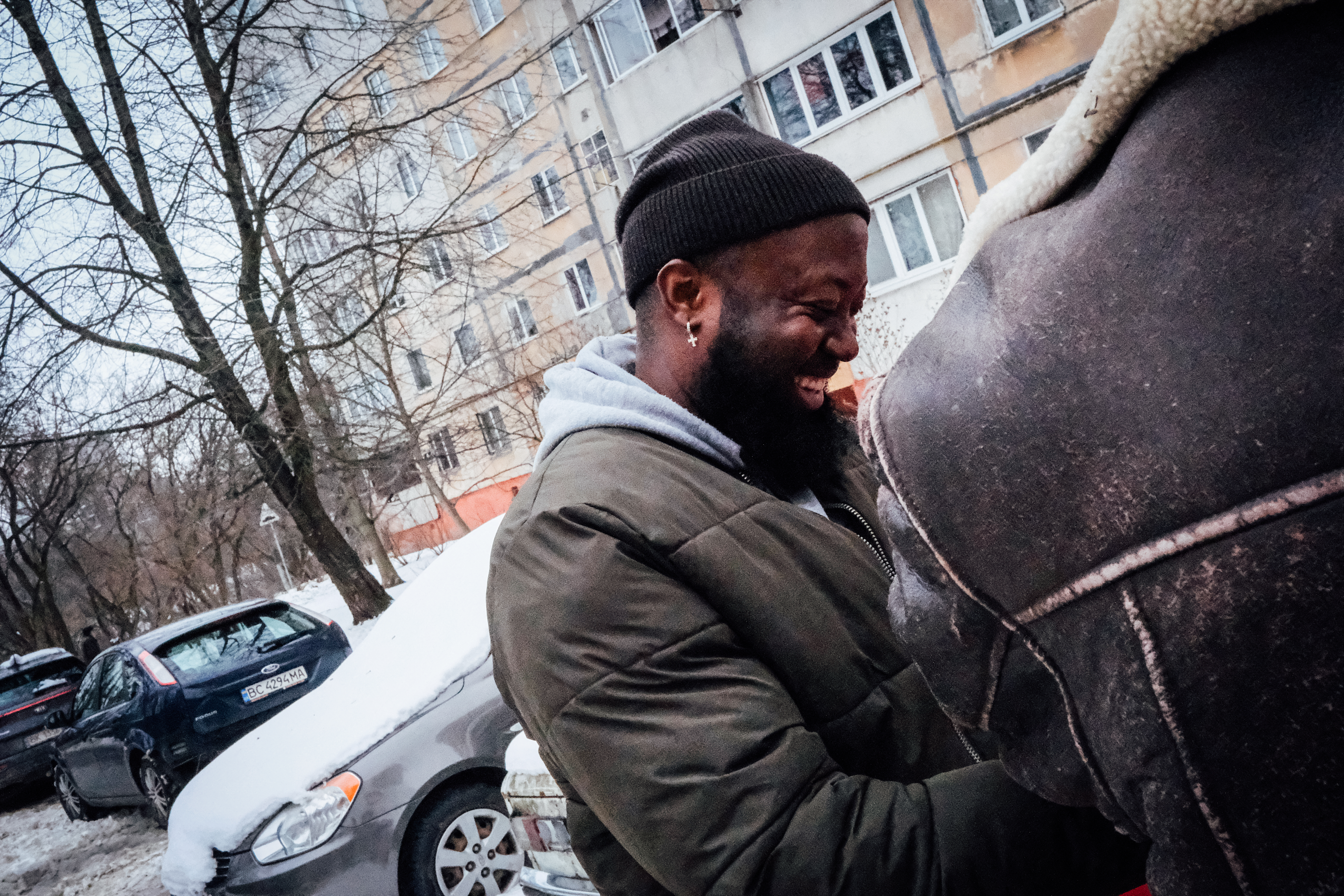 A photo of Nelly Nelson in a parking lot laughing with someone.