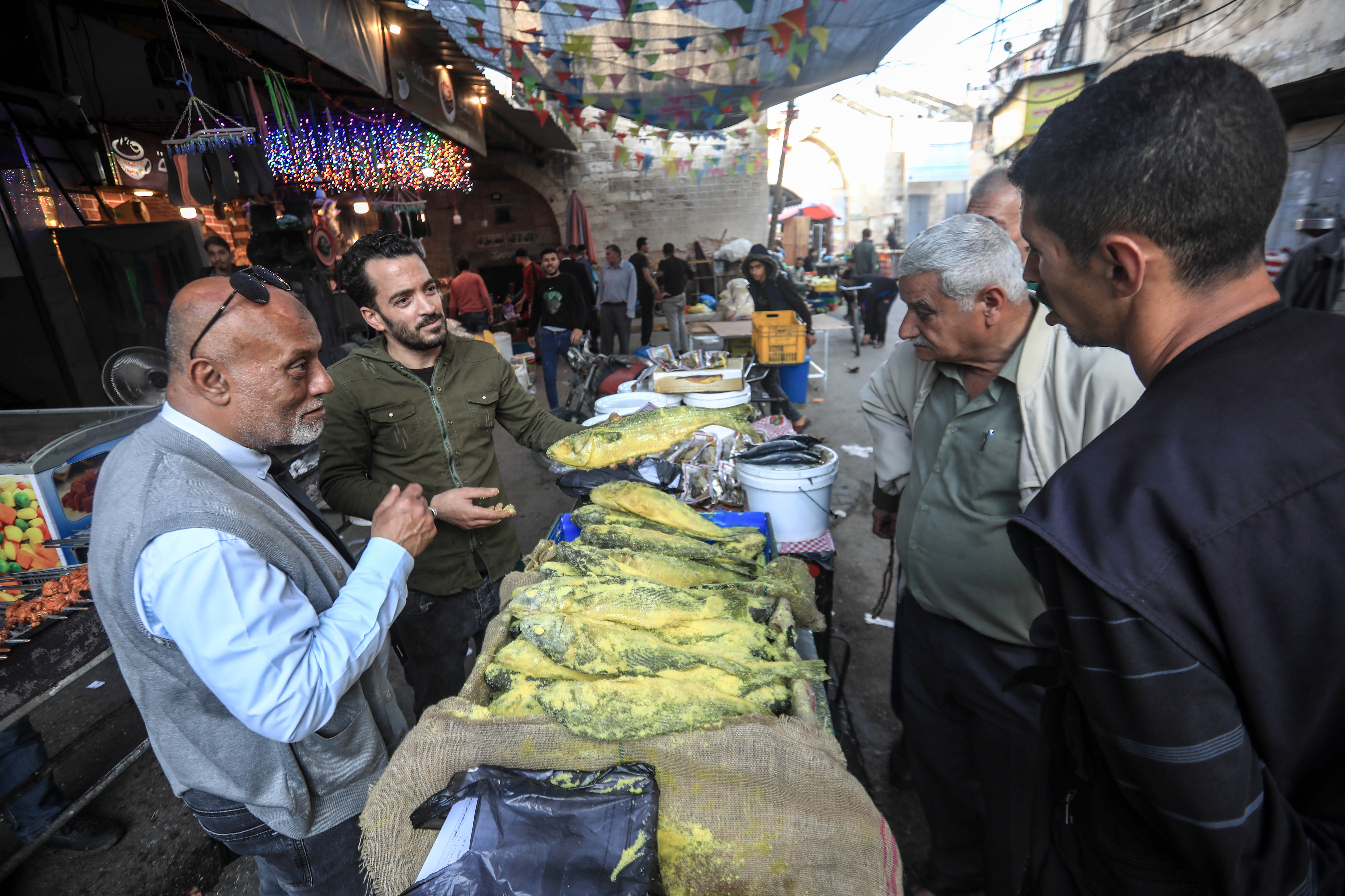 Shadi Khader, 37, who is from Gaza and supports four children, sells fesikh - a traditional salted fish - in the al-Zawiya market east of Gaza