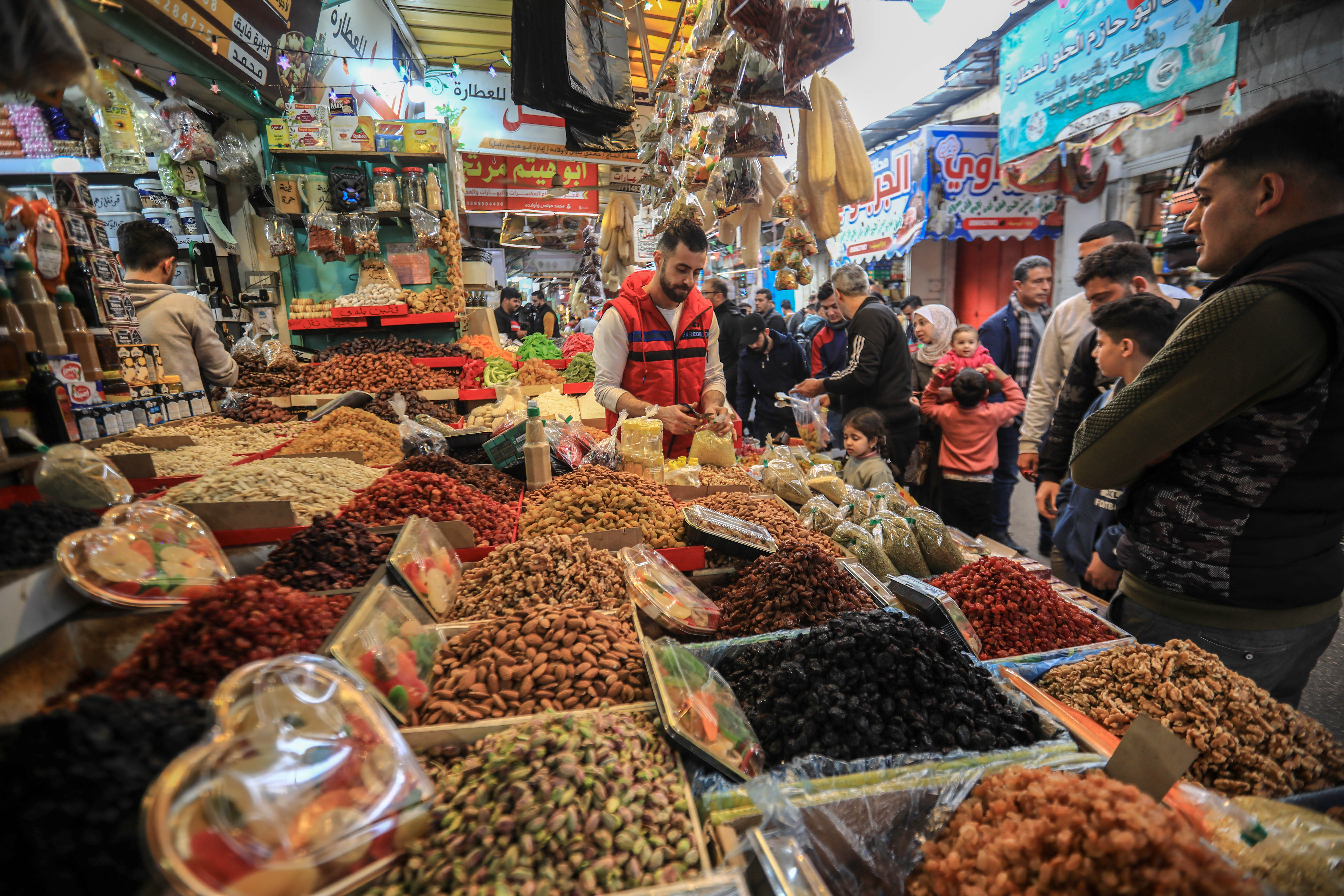 Ziyad Al-Hosari, 28, from Gaza, supports two children and works in a shop selling fruits, dried fruits and dates, in Al-Zawiya market, in the east of Gaza City. [Abdelhakim Abu Riash/Al Jazeera]