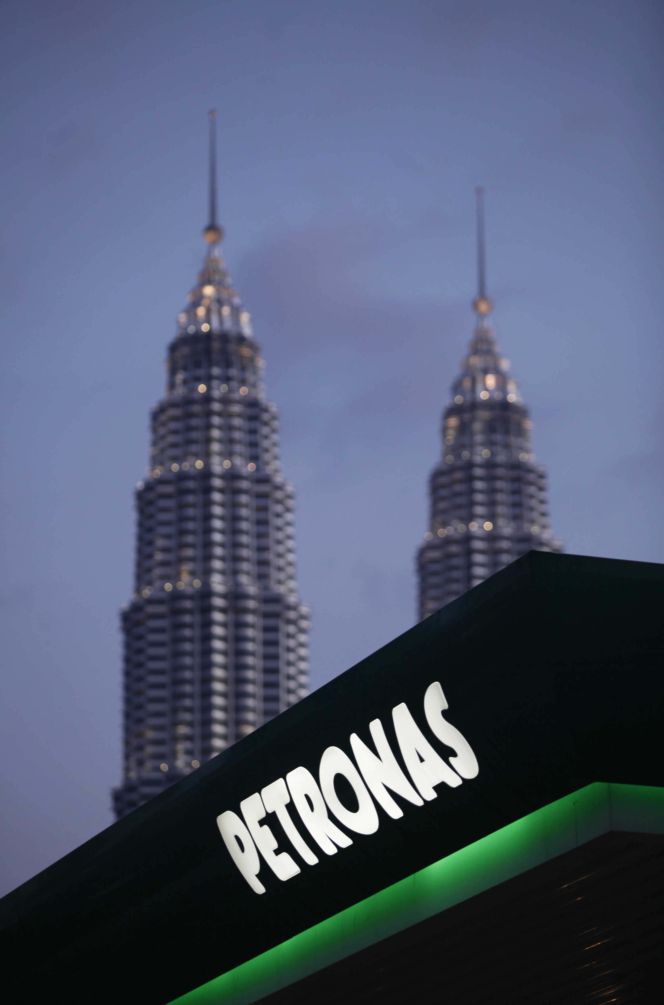 Petronas logo with the company's twin towers in the background.
