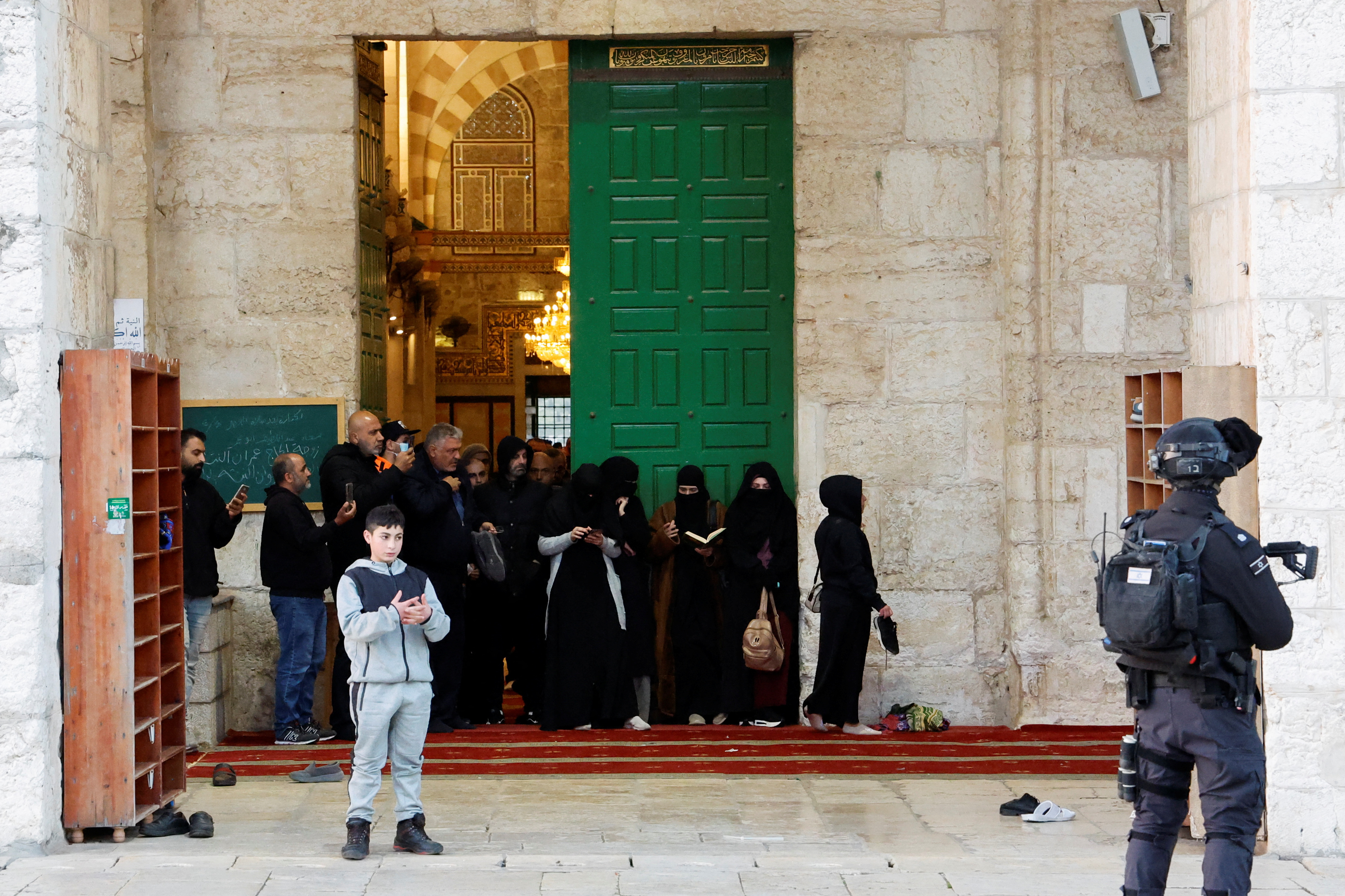 Palestinians pray as Israeli security forces take position at the Al-Aqsa Mosque