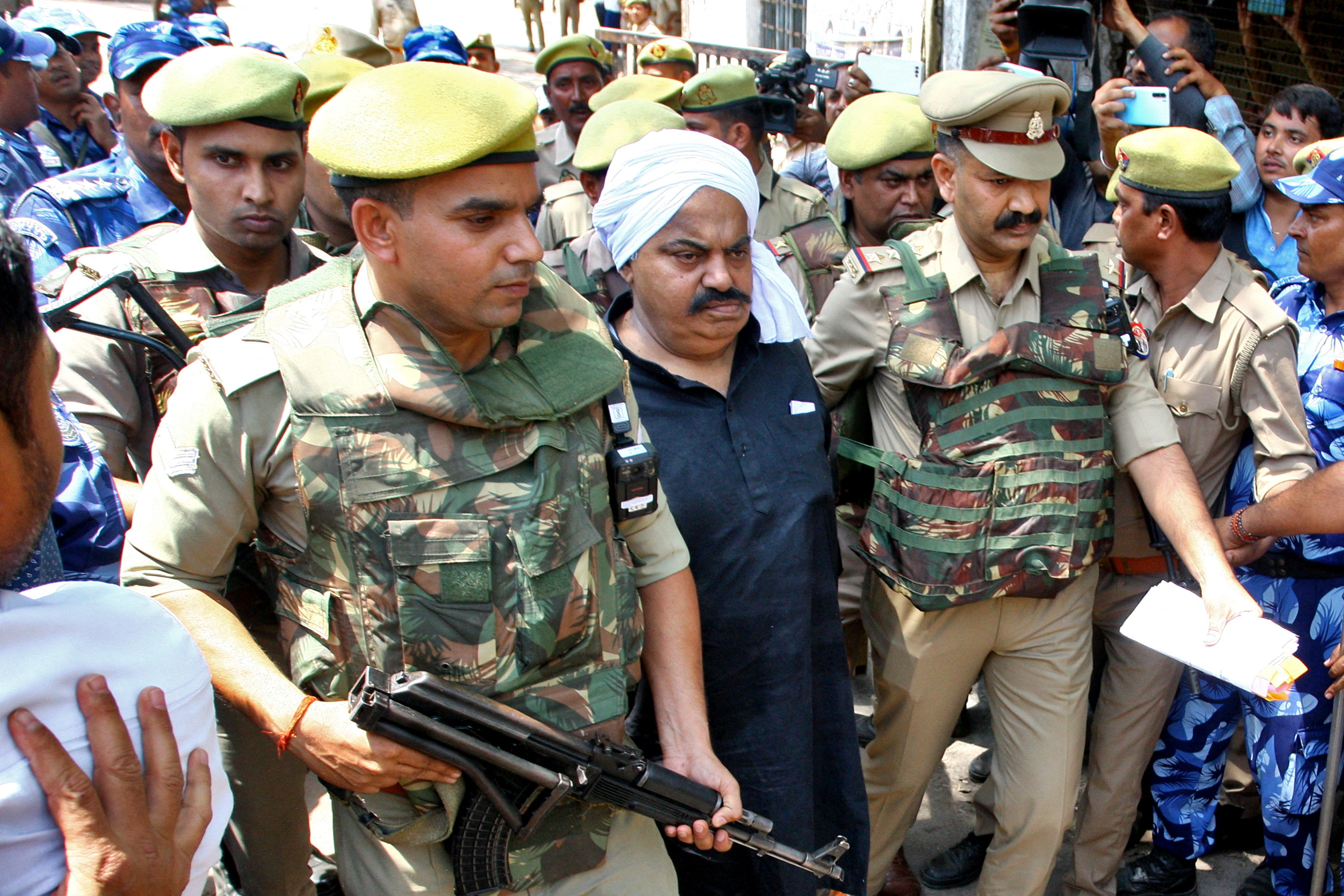 Police officers escort Atiq Ahmed, a former lawmaker in India's parliament, outside a court in Prayagraj