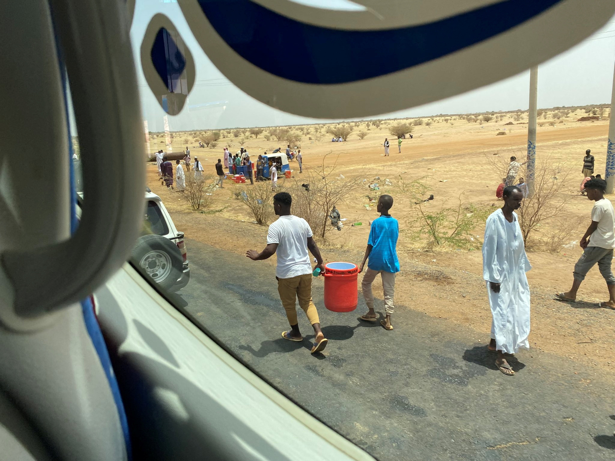 People carry kerkade (hibiscus) juice and cold water to distribute them to people amid evacuations from Khartoum to Port Sudan April 23, 2023 in this picture obtained from social media. Twitter@dalliasd/via REUTERS THIS IMAGE HAS BEEN SUPPLIED BY A THIRD PARTY. MANDATORY CREDIT.