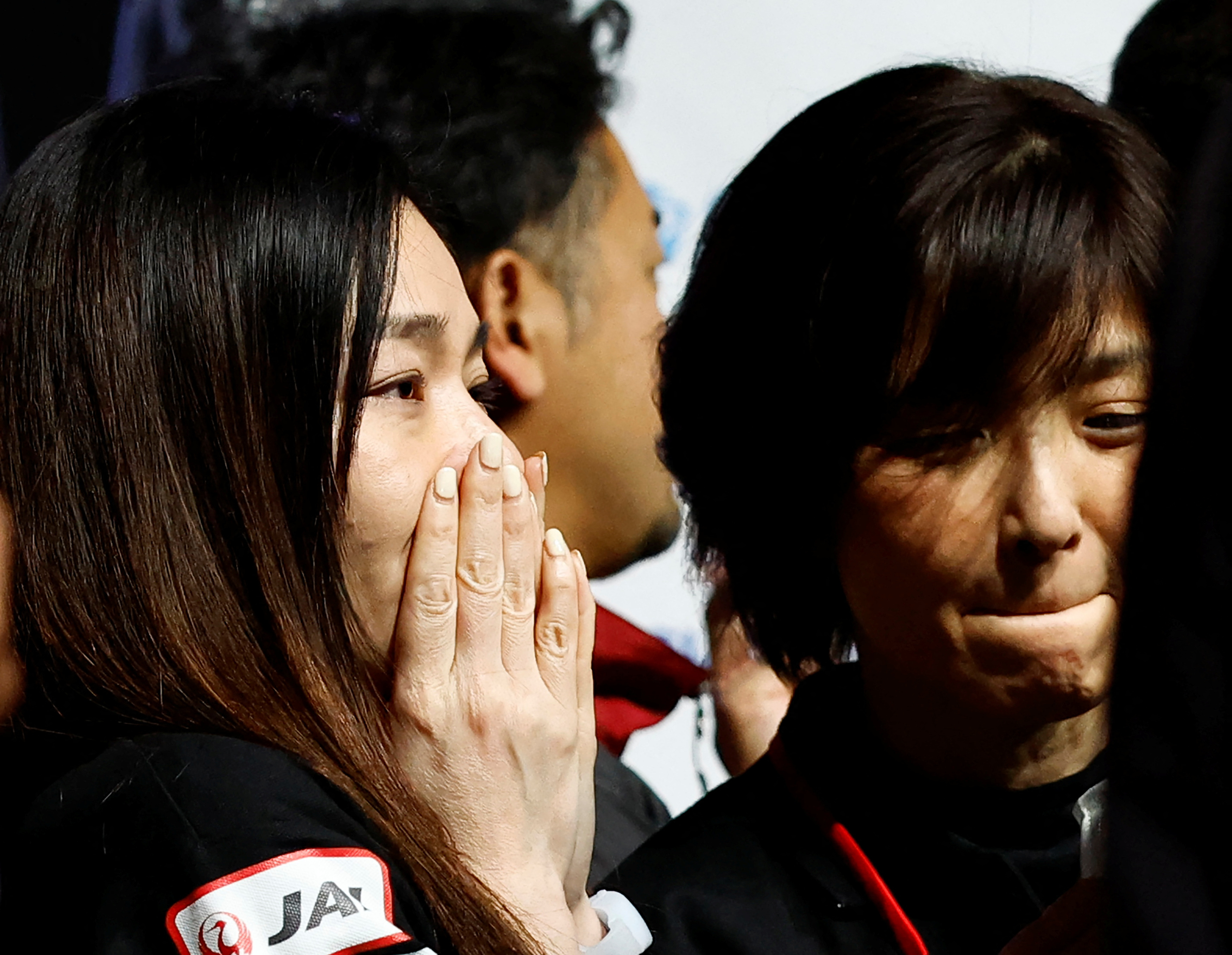 An ispace employee with her hands over her mouth in shock and another biting her bottom lip after the company announced it had lost contact with its Moon lander.